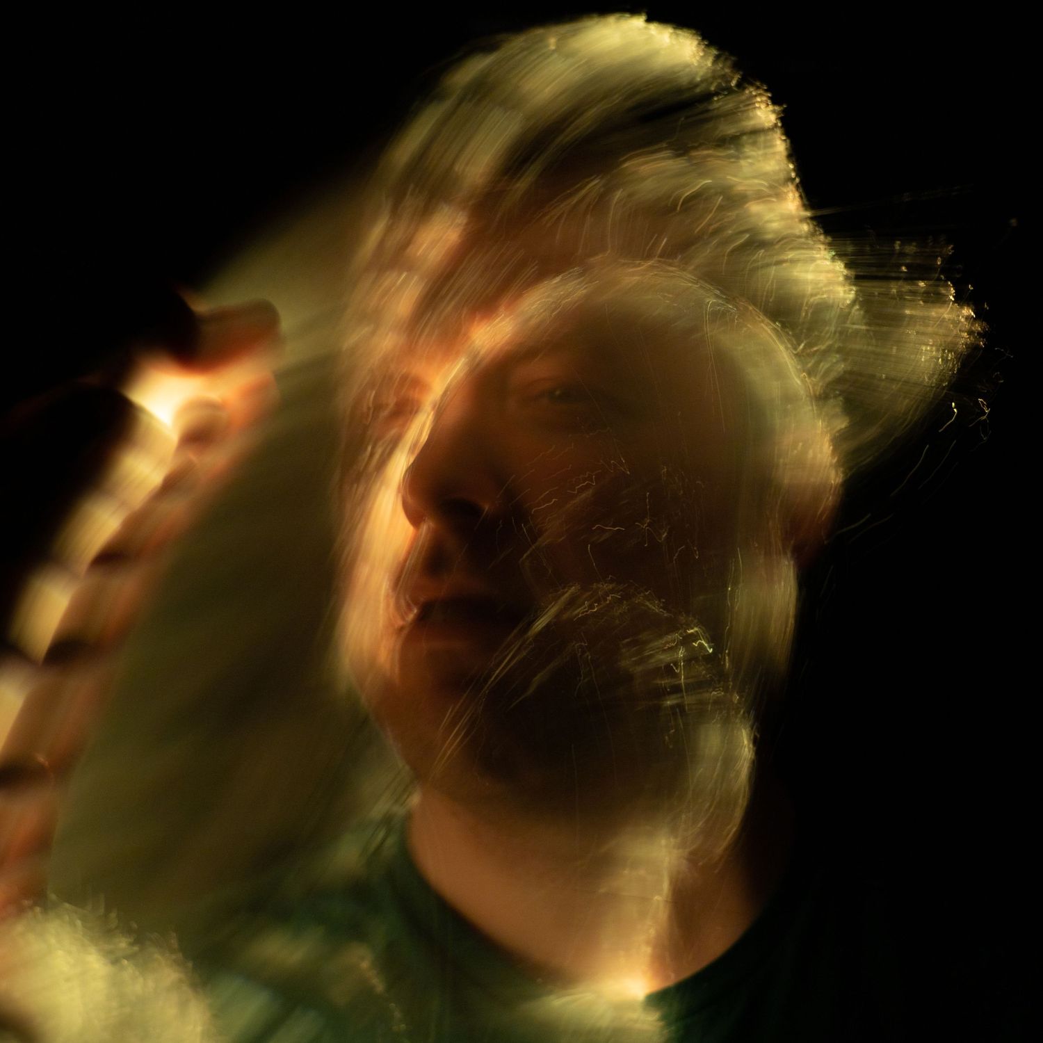 Golden light streaks creating an ethereal motion blur effect on black background.