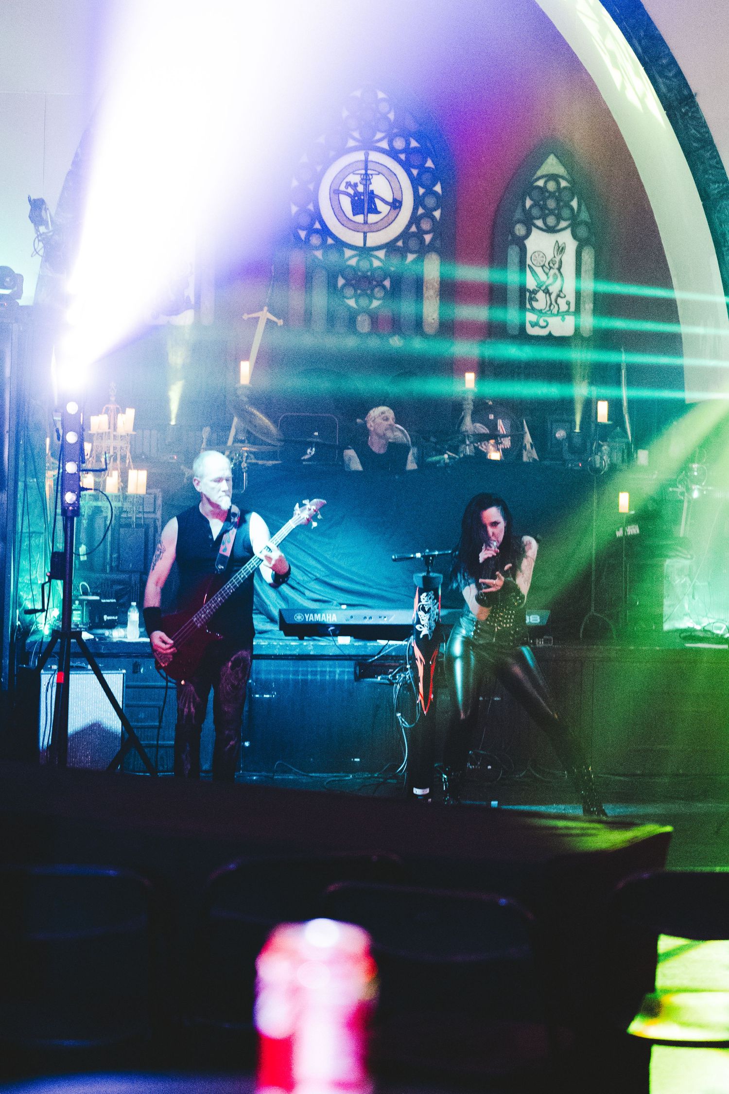 Musicians perform on stage with dramatic colorful lighting effects creating an atmospheric concert environment.