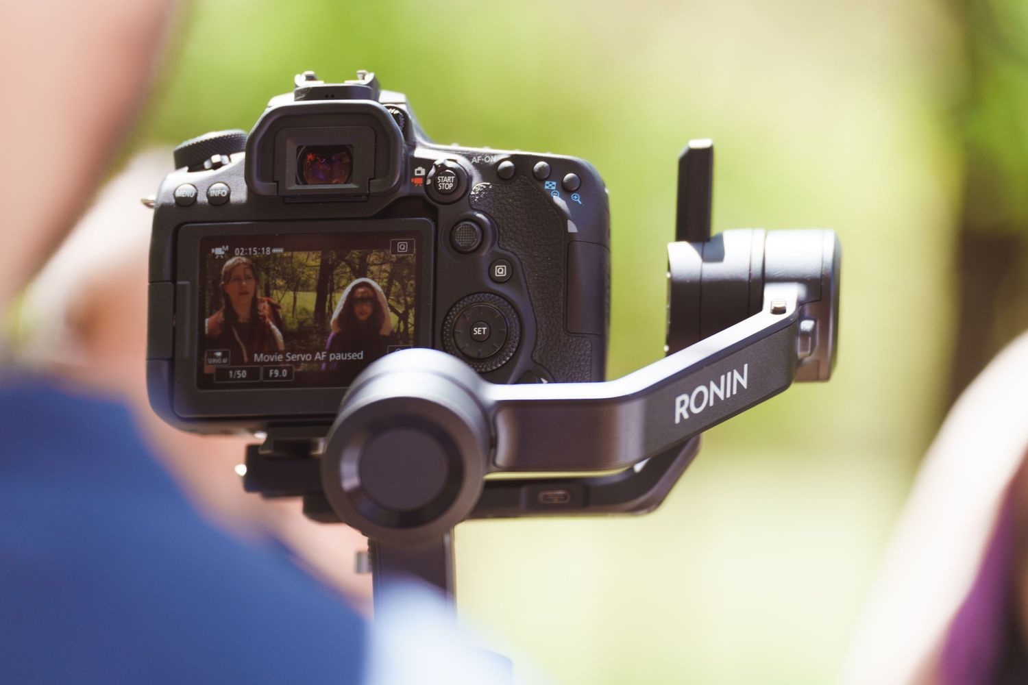 Close-up shot of a professional video camera mounted on equipment during an outdoor filming session.