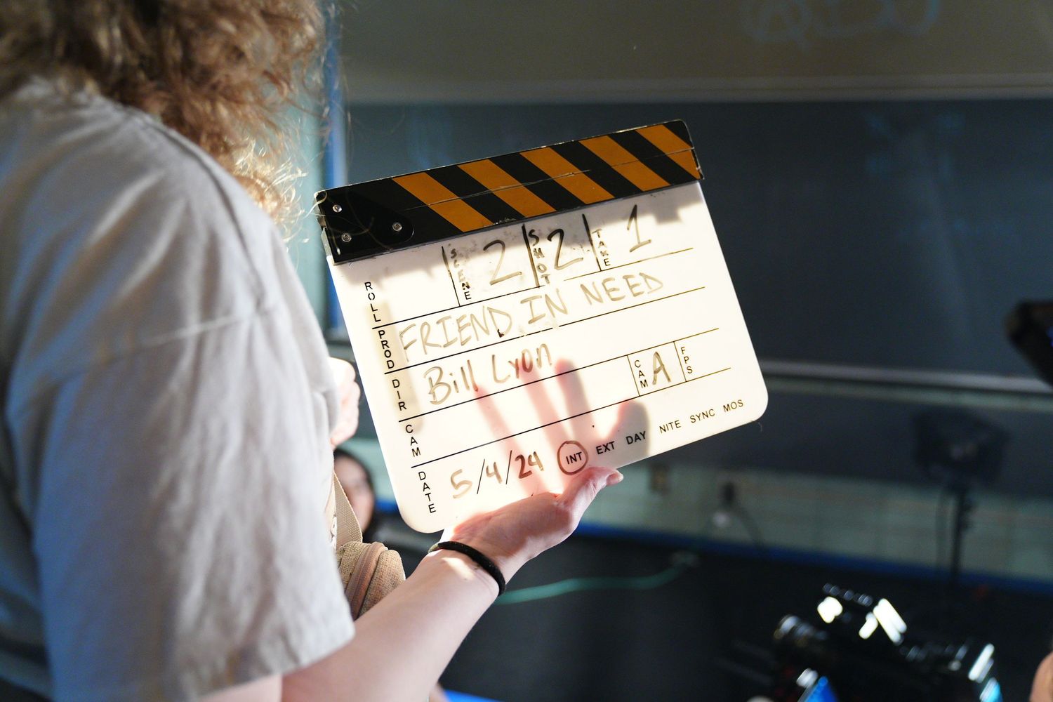 Behind the scenes shot of a film slate being used during production of 'Friend in Need'.