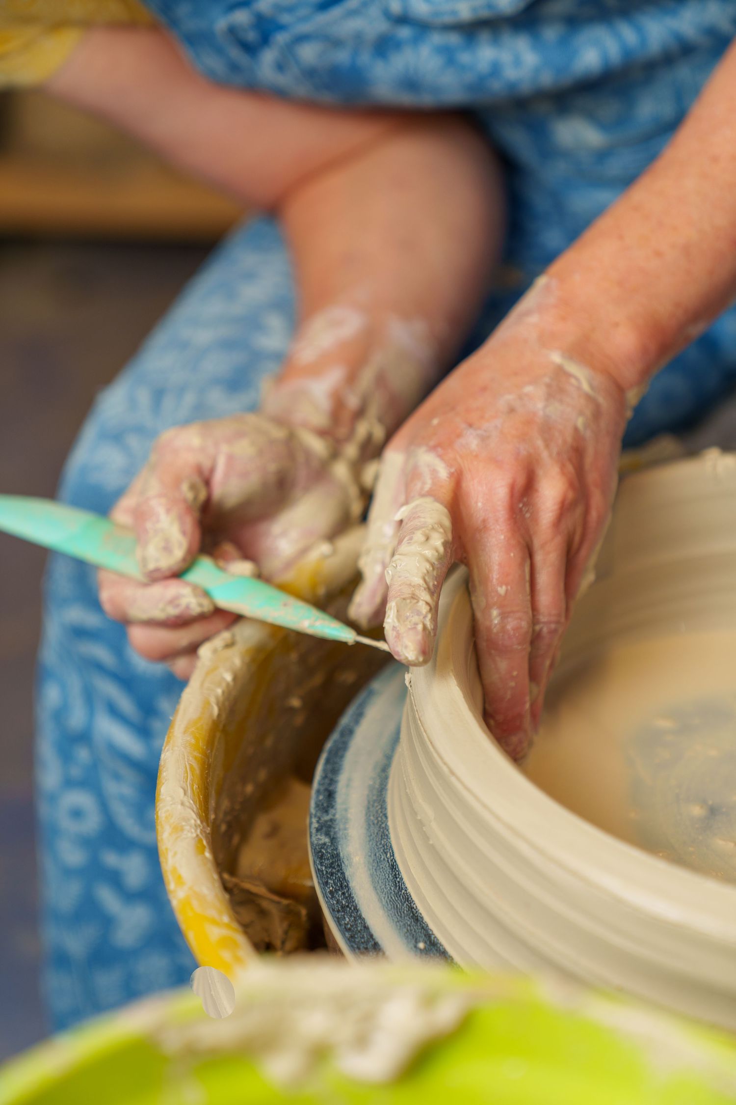 Close-up of hands working with clay on a pottery wheel.