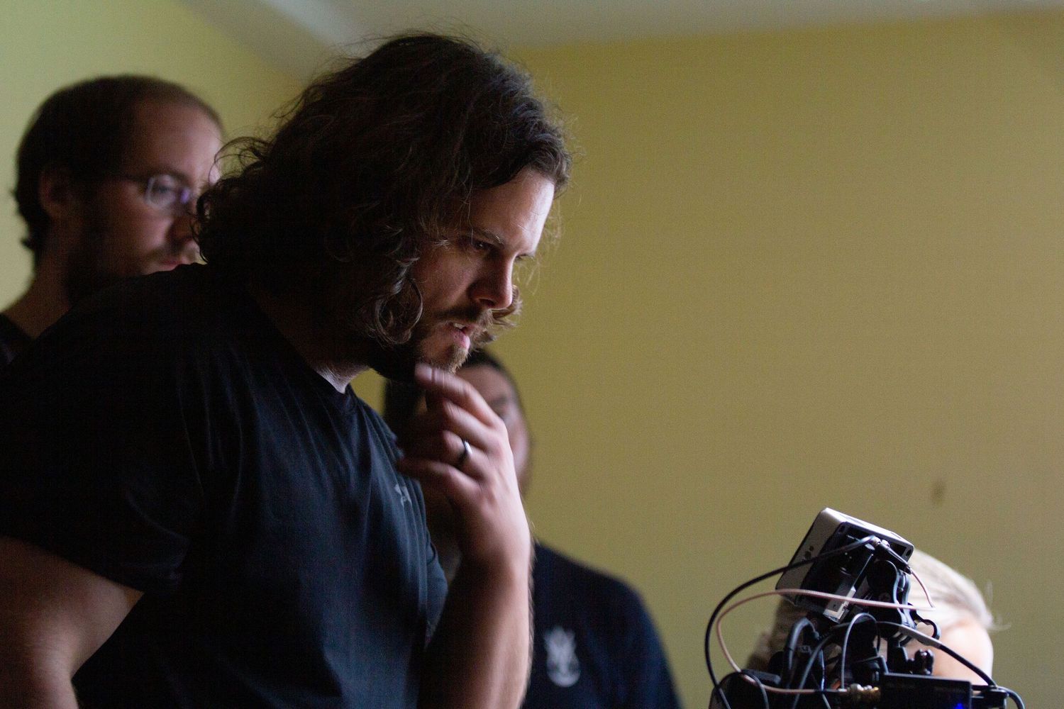 Film crew member reviewing footage on camera monitor.