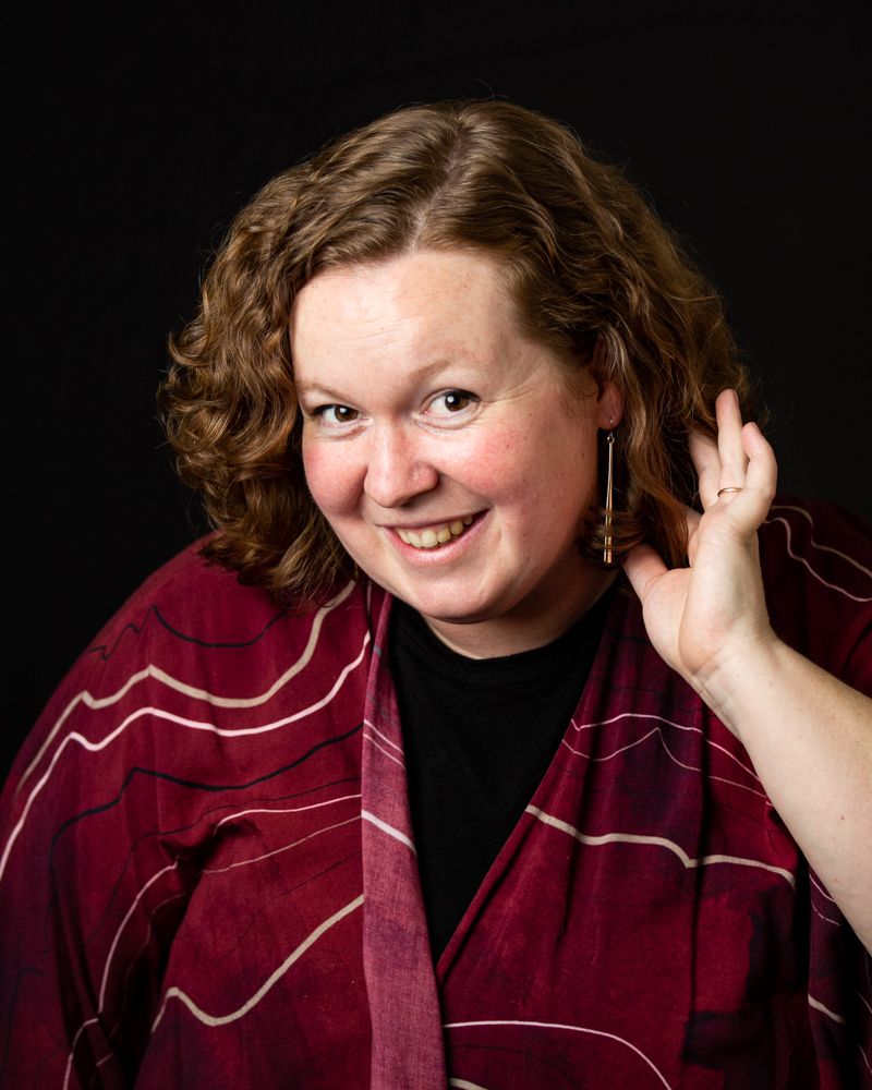 Portrait series showing playful expressions in a burgundy top against dark background.