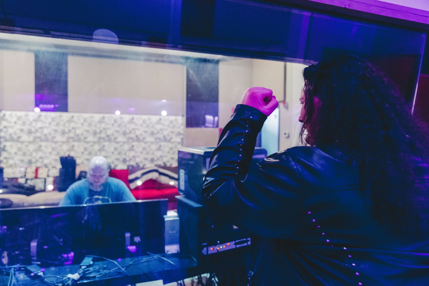 DJ performing at a nightclub with blue and purple lighting while working the turntables at night.