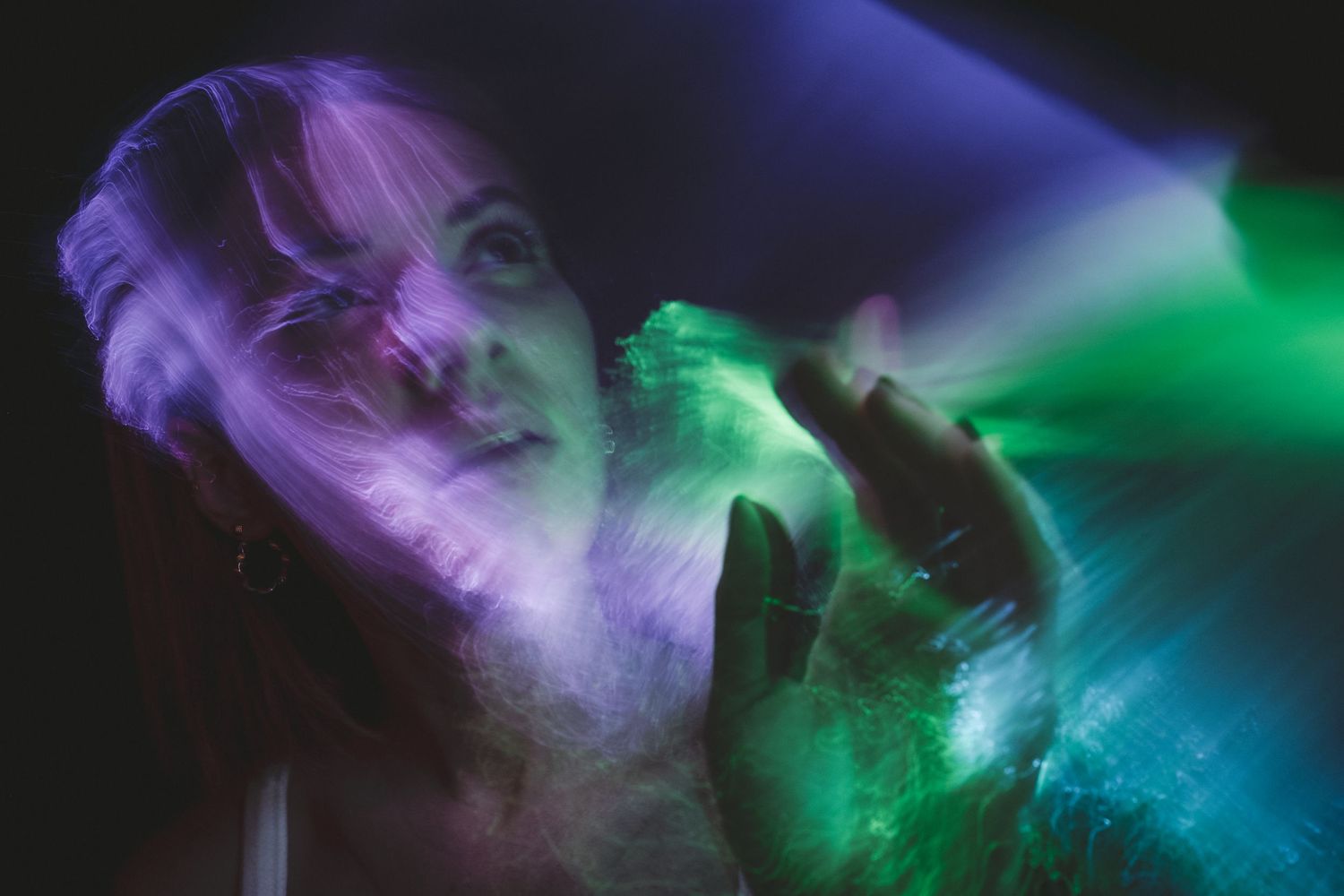 Purple and green light trails blend together creating mystical atmospheric effects.