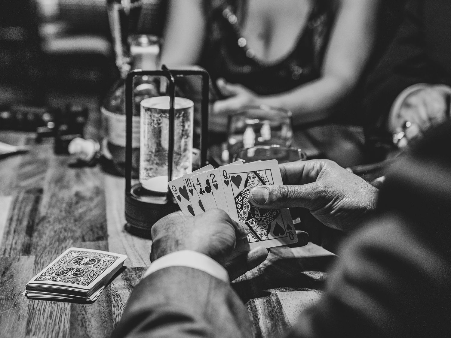 Row of bartenders preparing craft cocktails in dim lighting at a trendy bar counter.