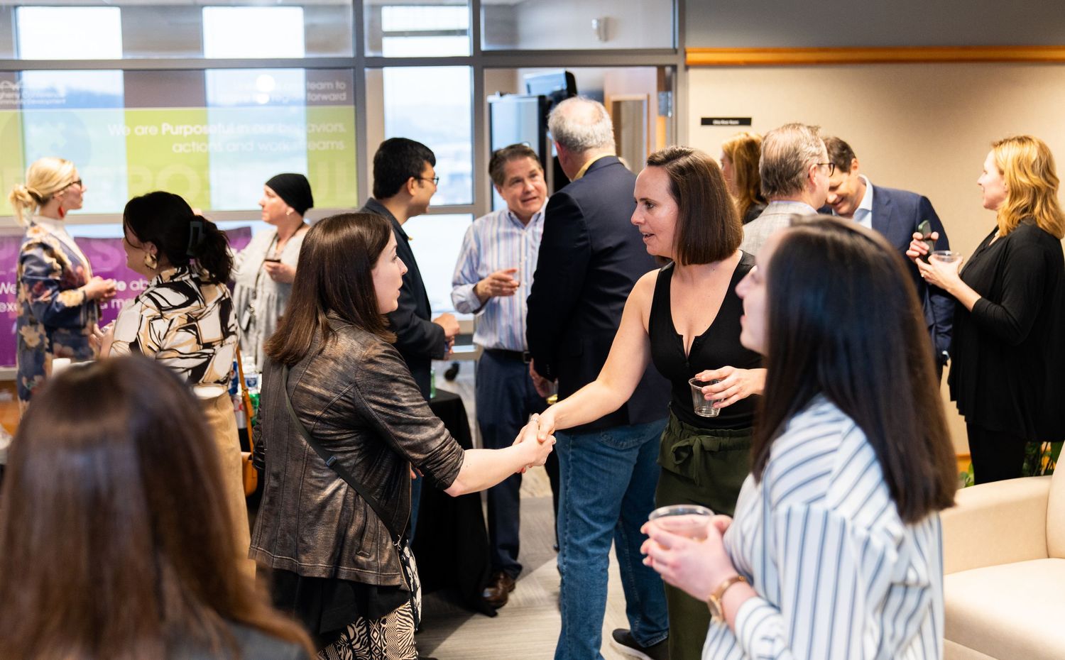 Group of people networking and socializing at a professional business event.