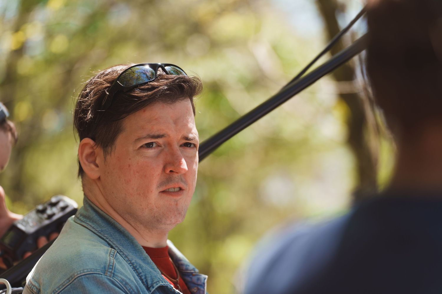 Behind the scenes footage of a film production crew working in a forest setting.