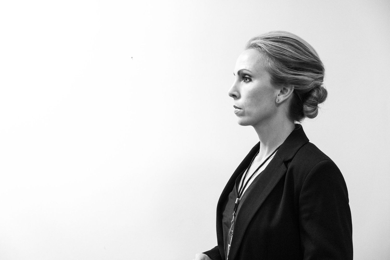 Black and white profile portrait of an elegant blonde woman in a dark blazer with hair in an updo.