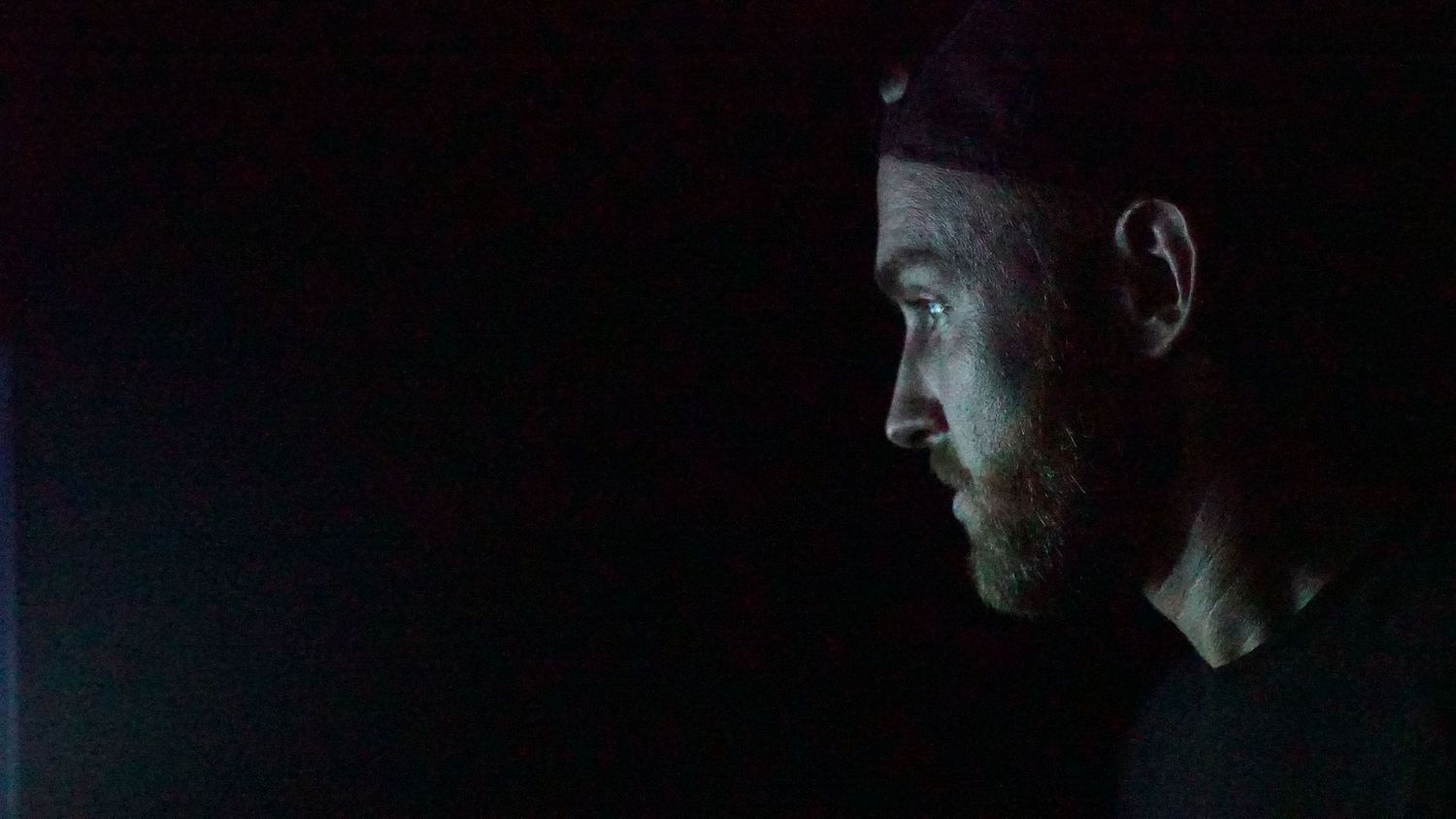 Side profiles of figures emerging from darkness with dramatic rim lighting.