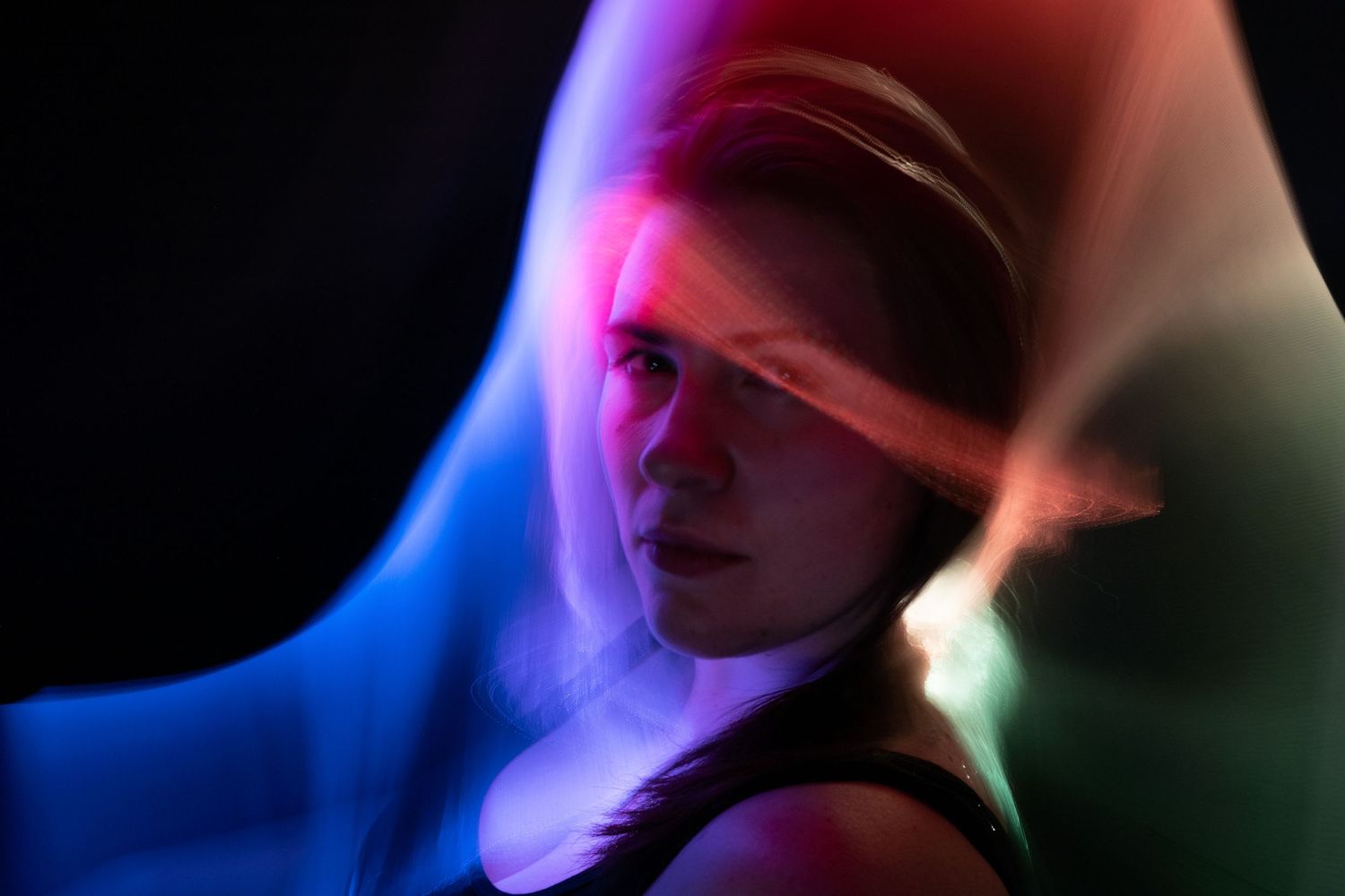 Artistic long exposure photo showing blurred movement with blue and pink lighting effects.