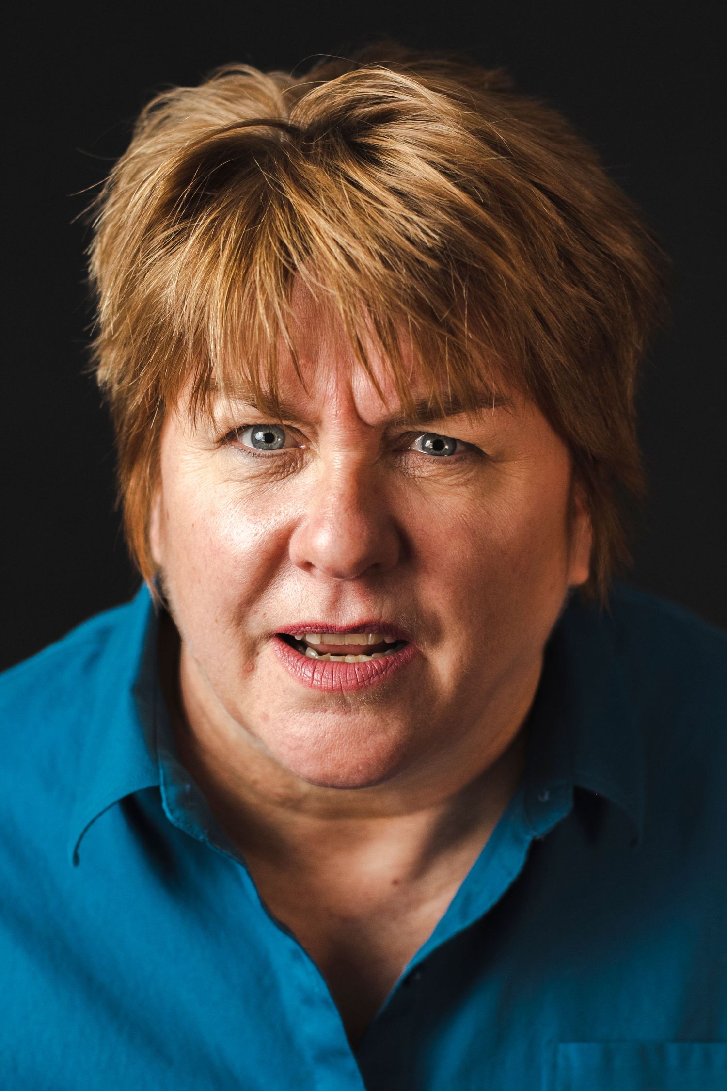 Portrait series showing different emotional expressions against dark background while wearing bright blue clothing.