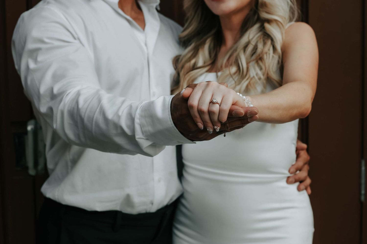 couple holding hands looking at eachother during their engagement session in downtown lethbridge alberta