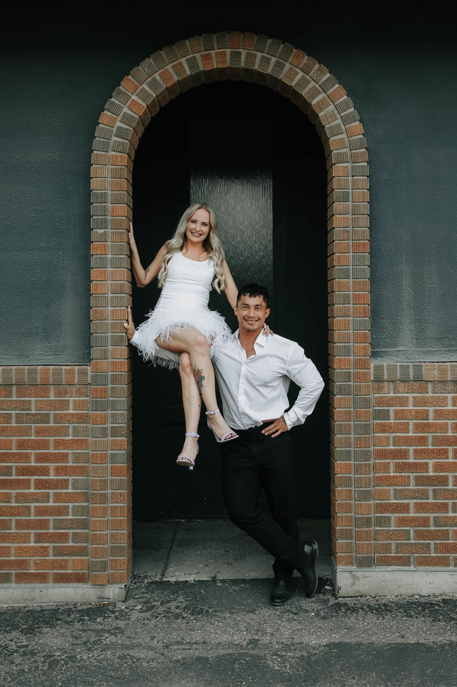 bodybuilder lifts fiancee onto his shoulders during their downtown engagement session in lethbridge alberta