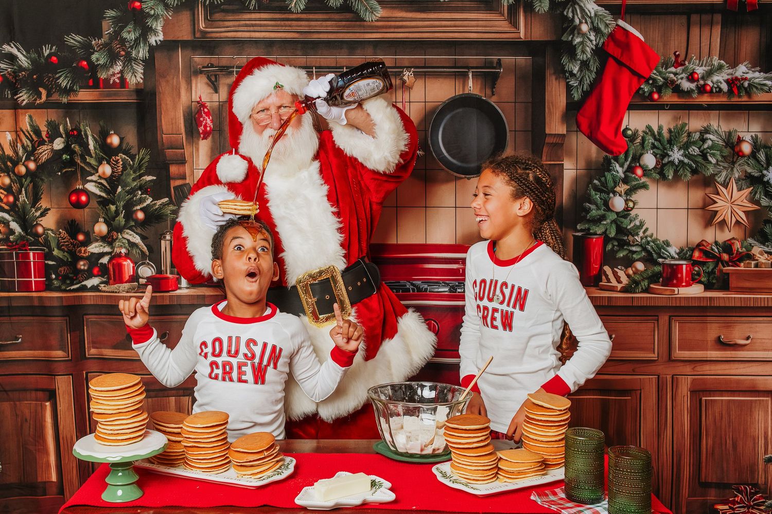 Group enjoying holiday treats and hot cocoa at a festive Christmas gathering with Santa decorations and red accents.
