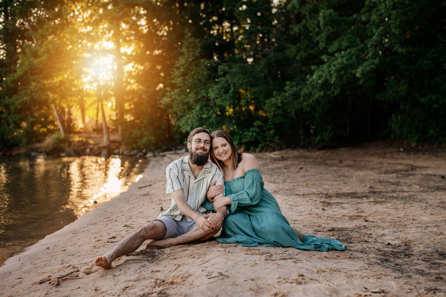 Romantic beach photoshoot with couple lounging on sand during golden hour.