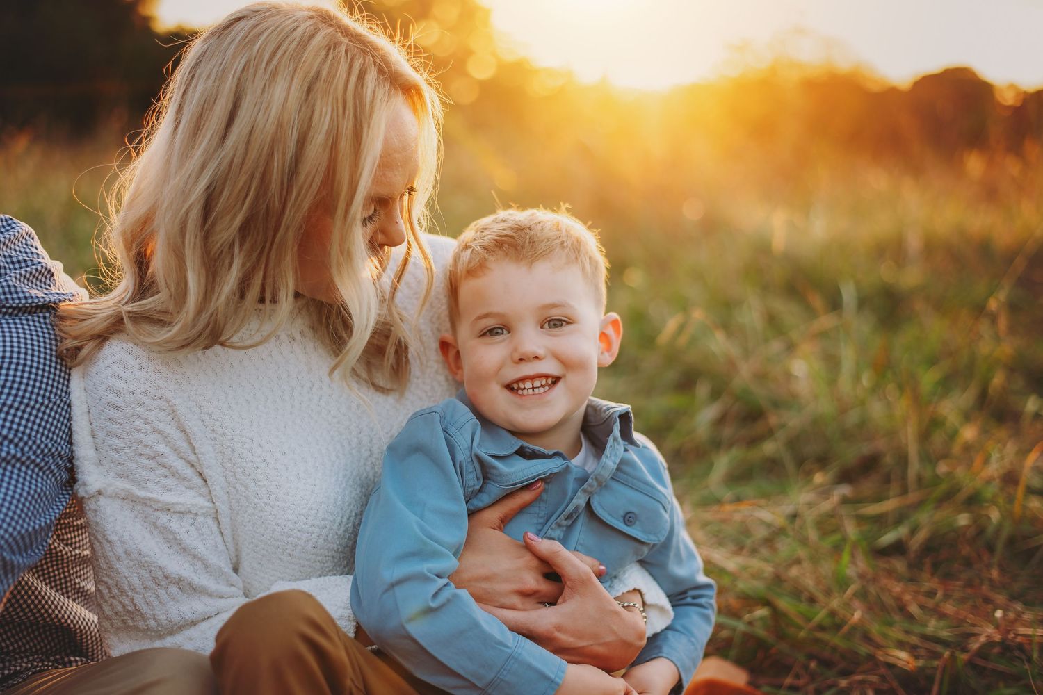 Mom and child tender moment in a grassy field in Mooresville NC during golden hour.