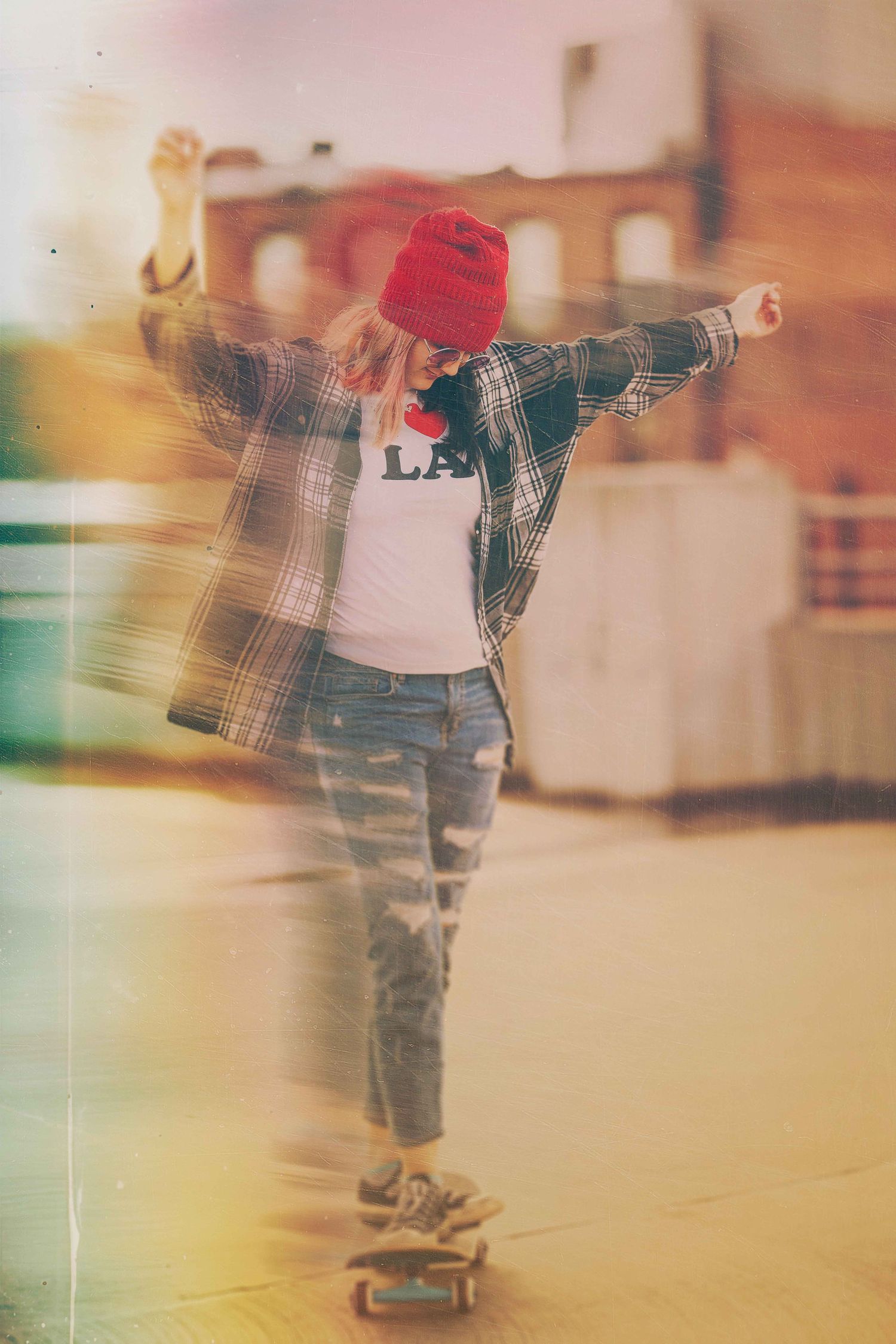 Skateboarder in plaid shirt and red beanie balancing on board with arms outstretched in vintage-style photo.