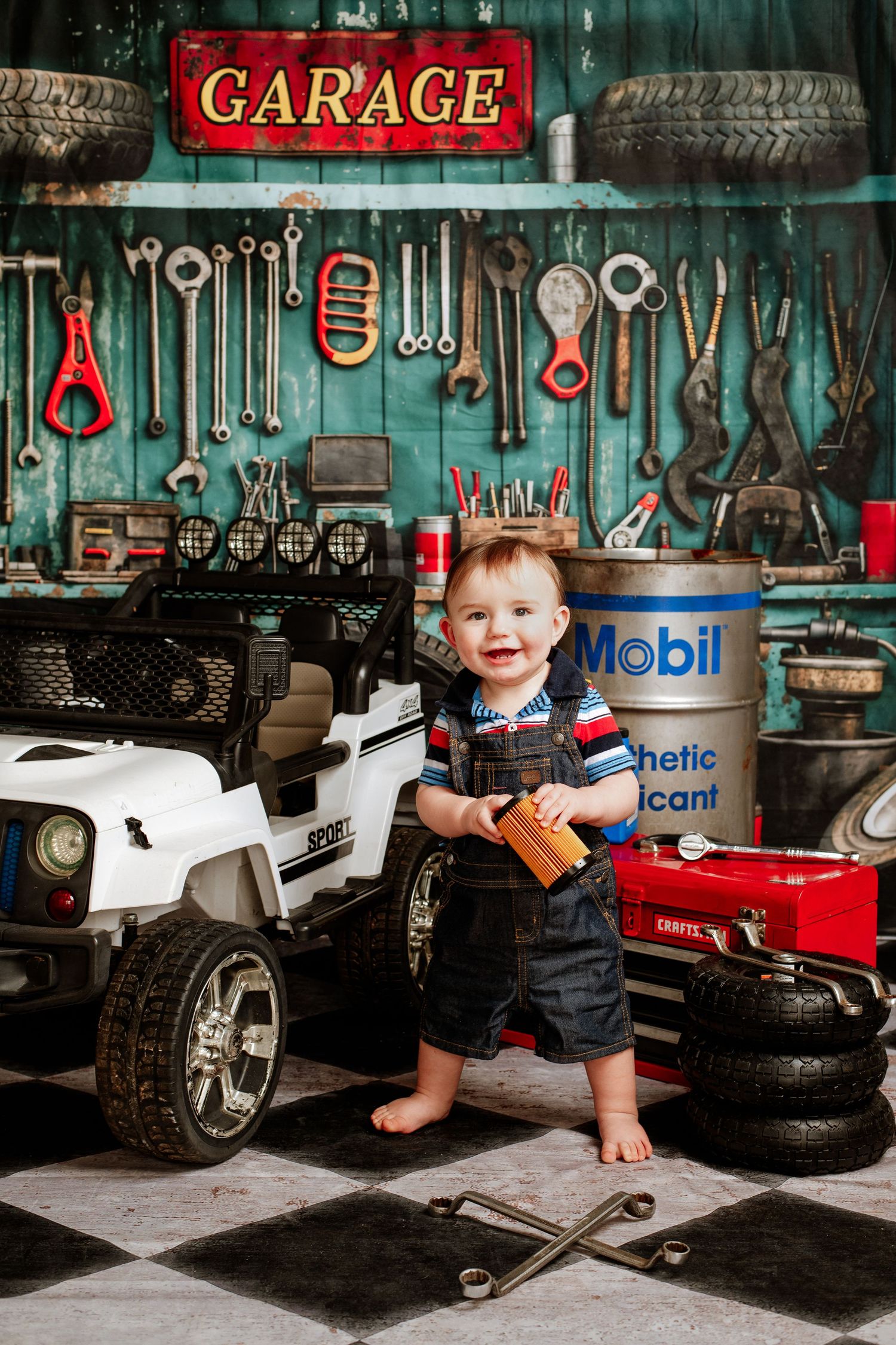 A vintage-style garage setup with tools on wall, toy cars, and checkered floor creates nostalgic automotive scene.