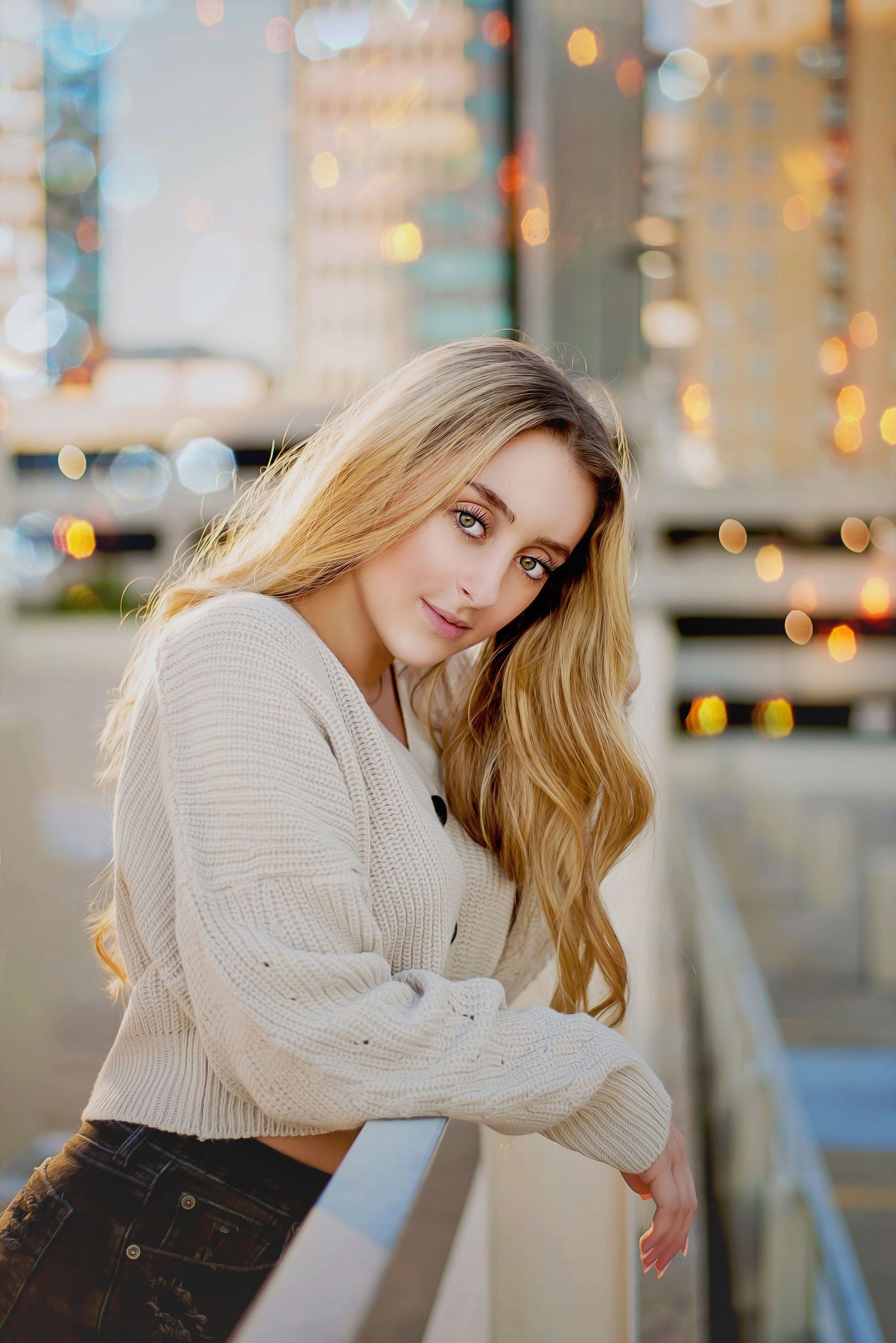 Portrait in warm lighting with bokeh background wearing cream sweater and jeans.