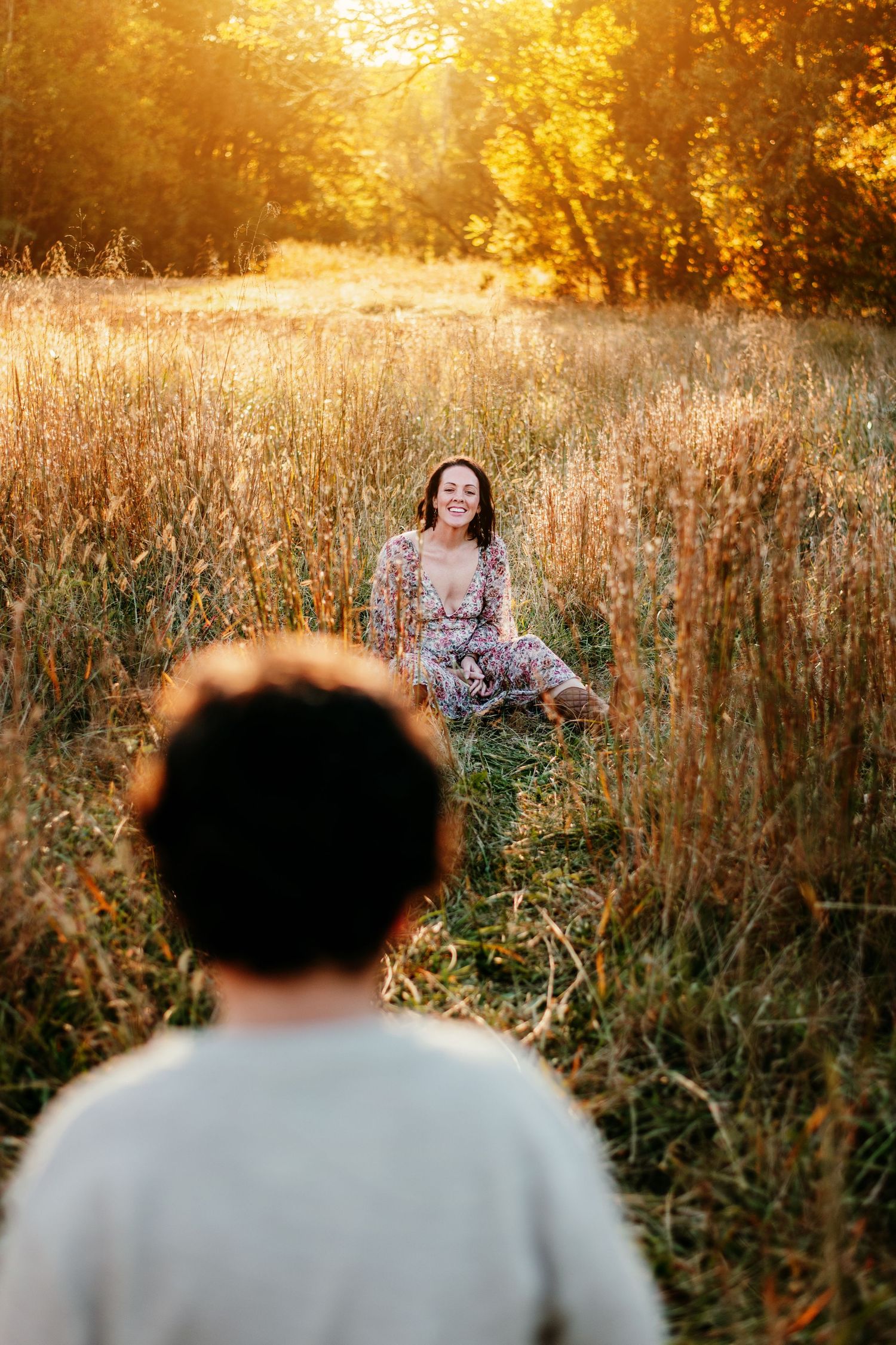 Candid outdoor portrait session in golden wheat field at sunset.