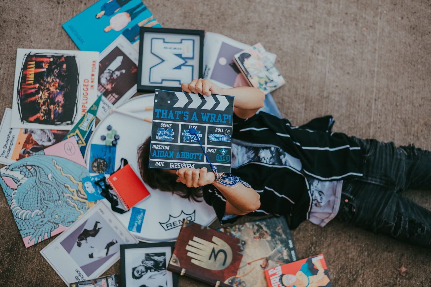 Aerial view of person lying on floor surrounded by scattered photographs and memorabilia.