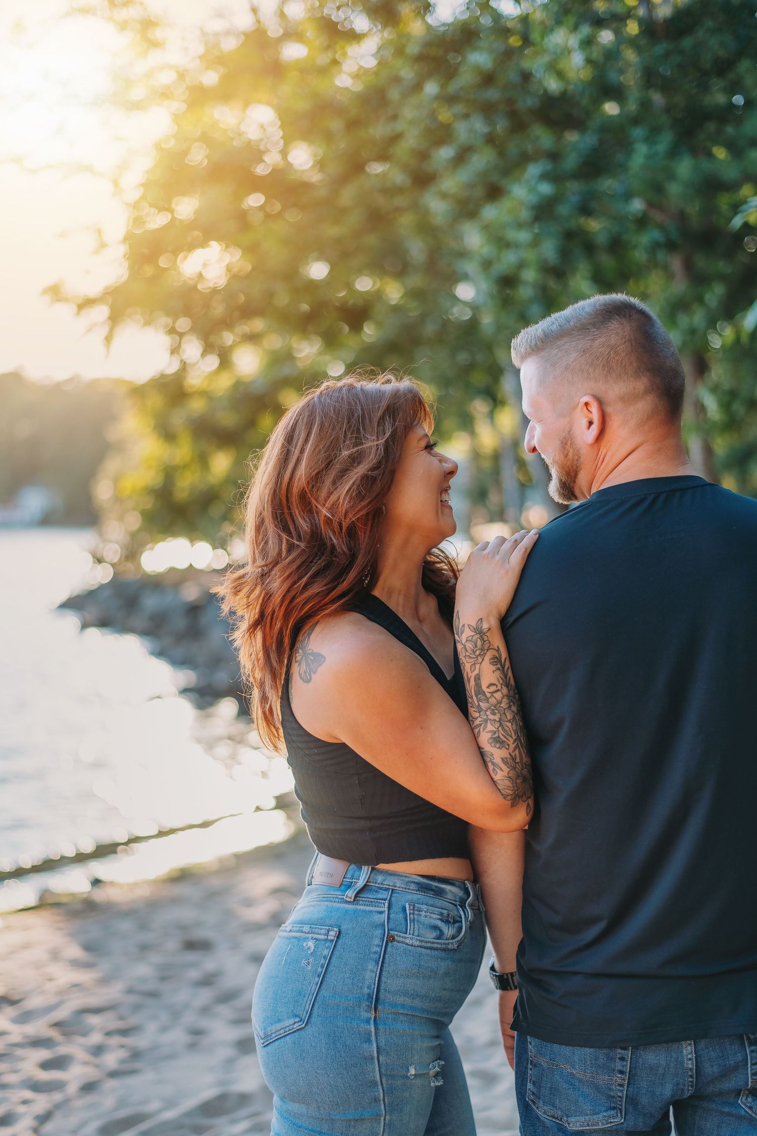 Intimate beach photoshoot showing couple in casual attire during sunset.