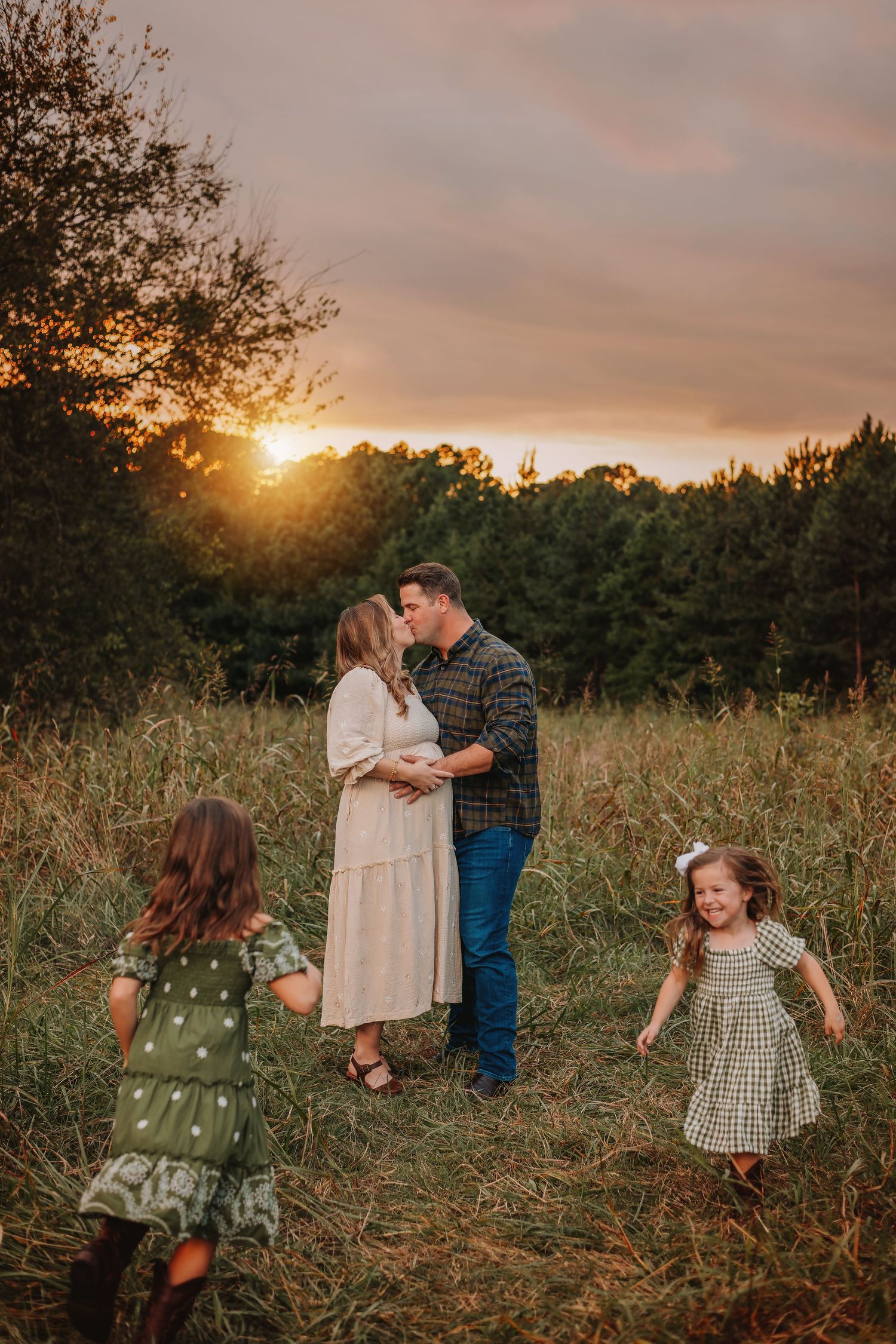 Family moment captured during golden hour in a rustic field setting.
