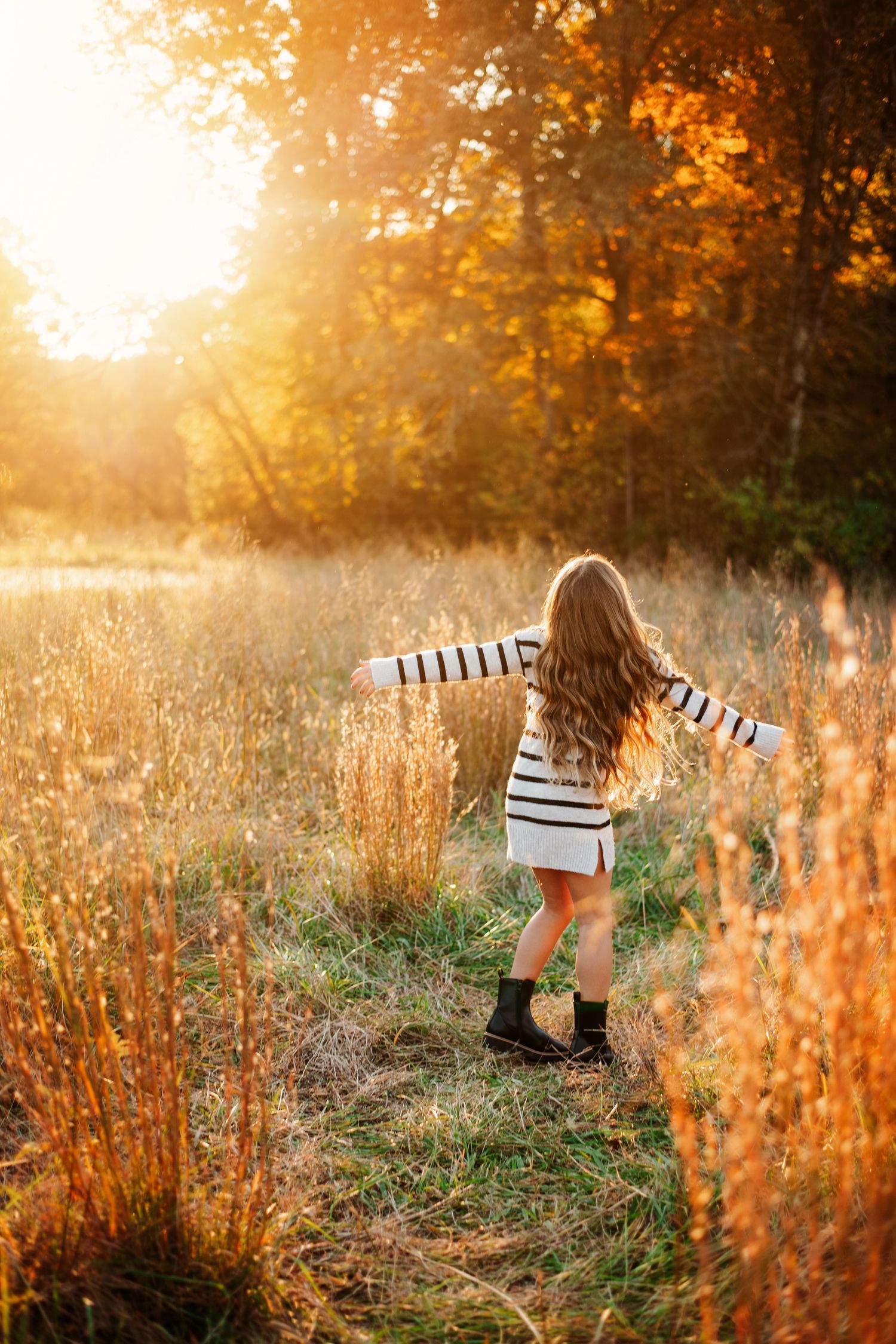 Joyful movement captured in golden sunlight among autumn grasses.