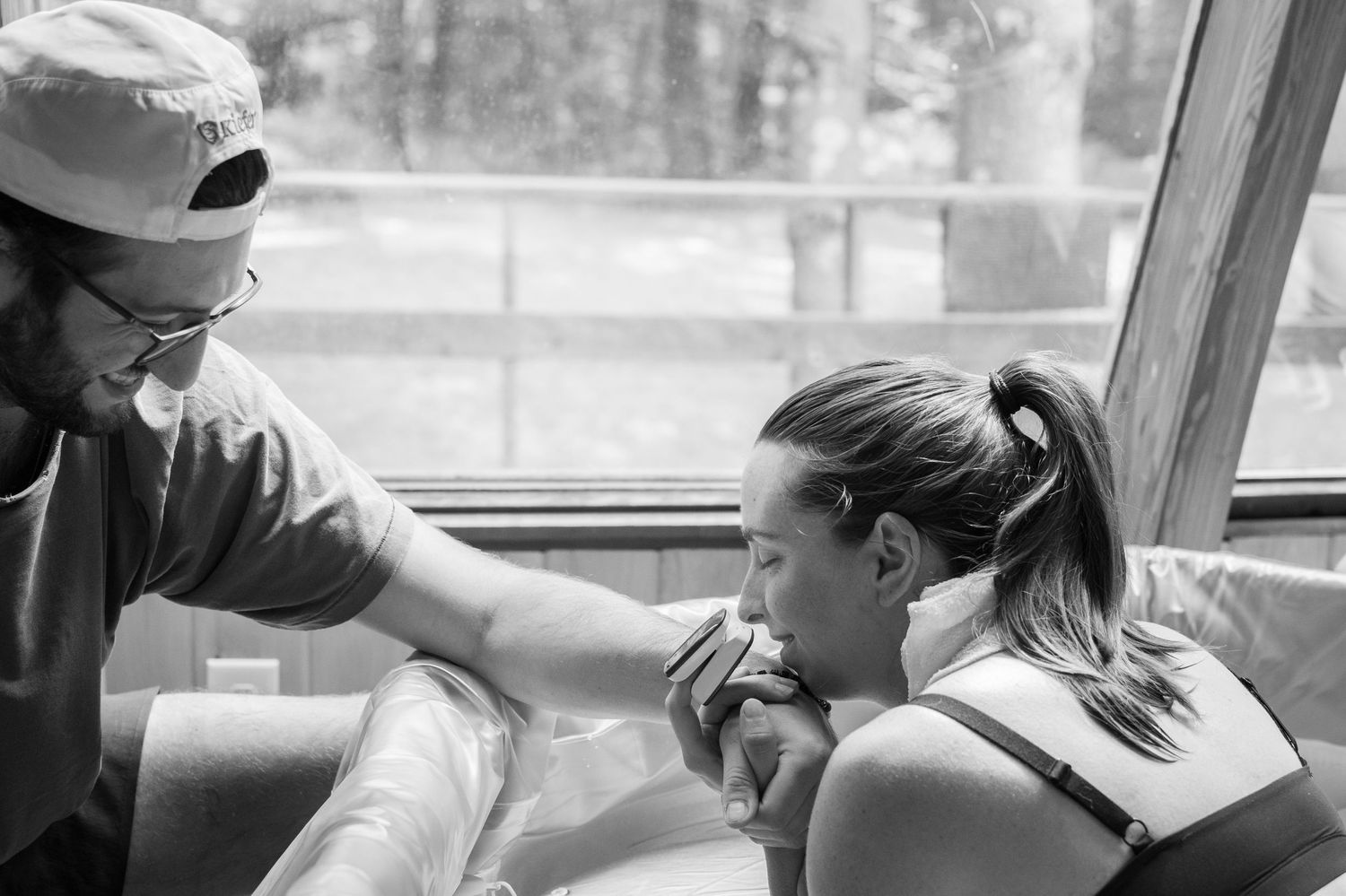 Black and white photo of a man and woman sharing a tender moment during a home birth.