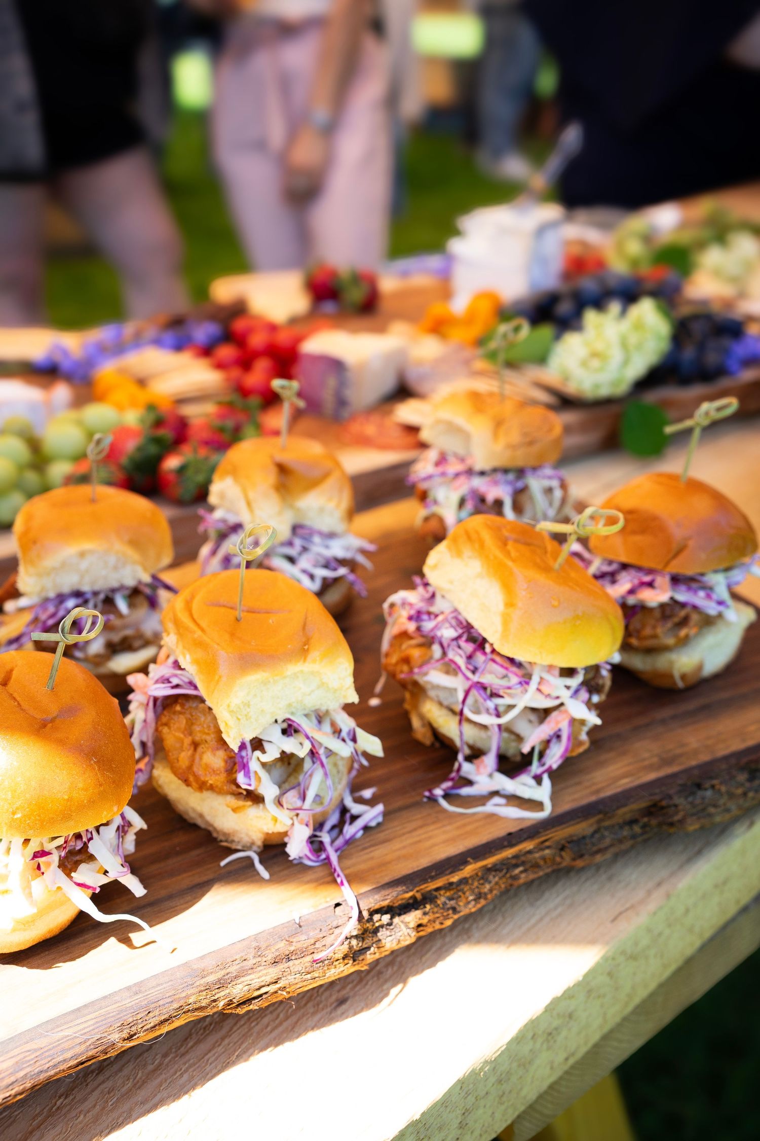 Event catering photo filled with mini fried chicken sandwiches topped with coleslaw, secured by toothpicks, made by a private chef.