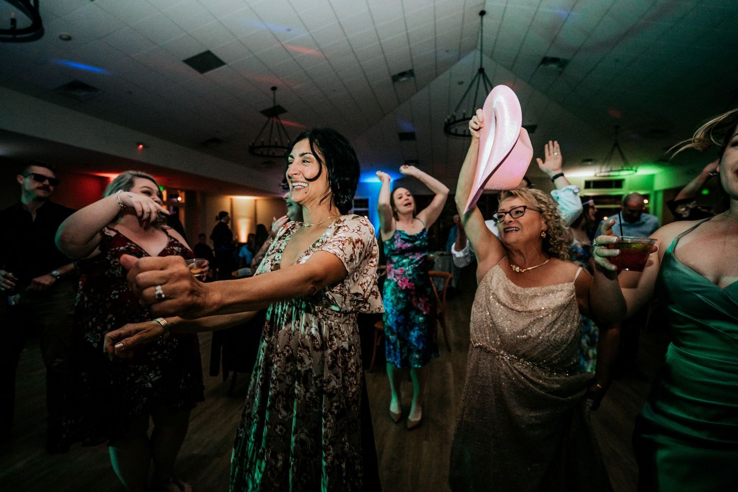 Group of women dancing and celebrating joyfully at a lively wedding reception party.