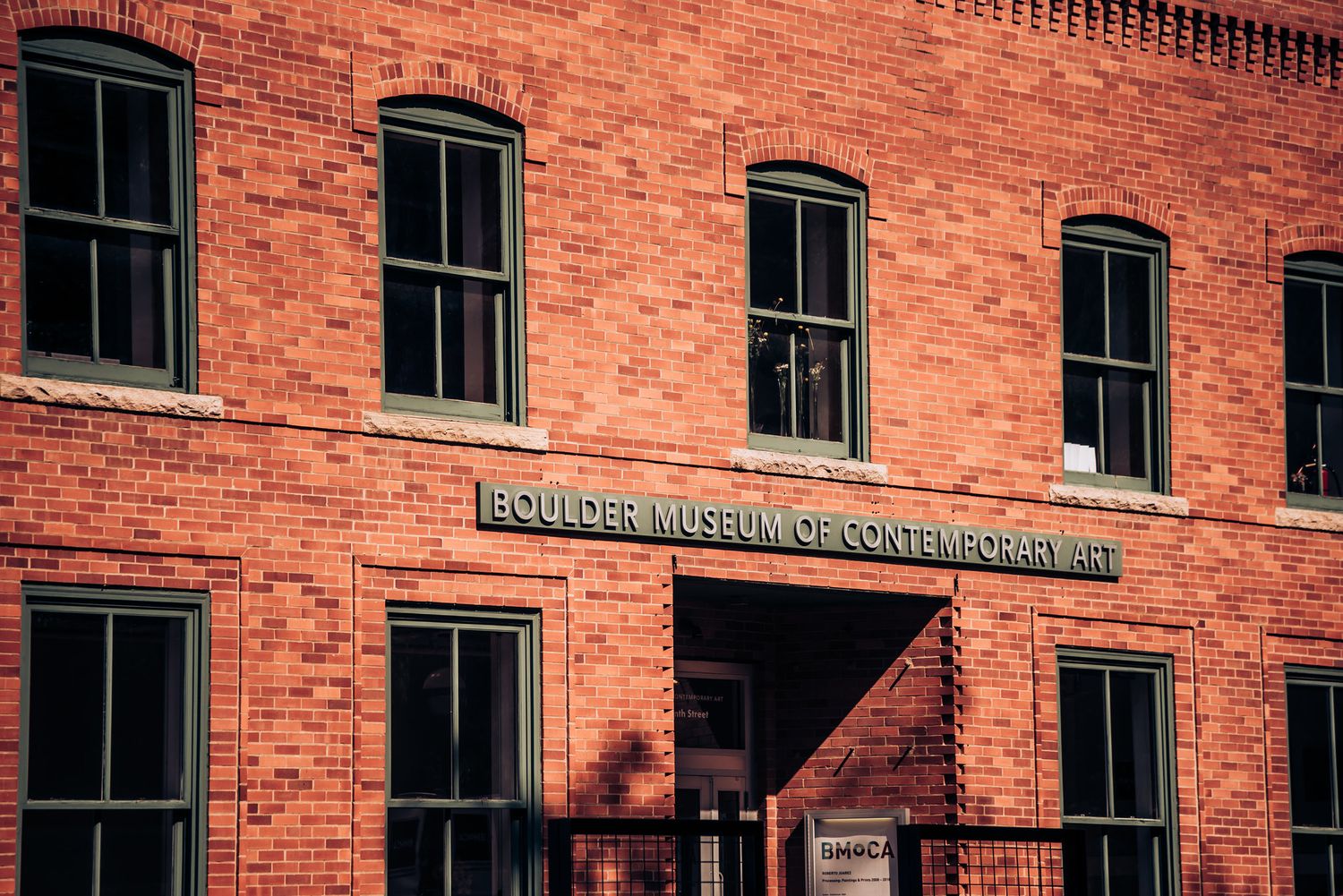 Historic red brick building facade with vintage windows and signage.