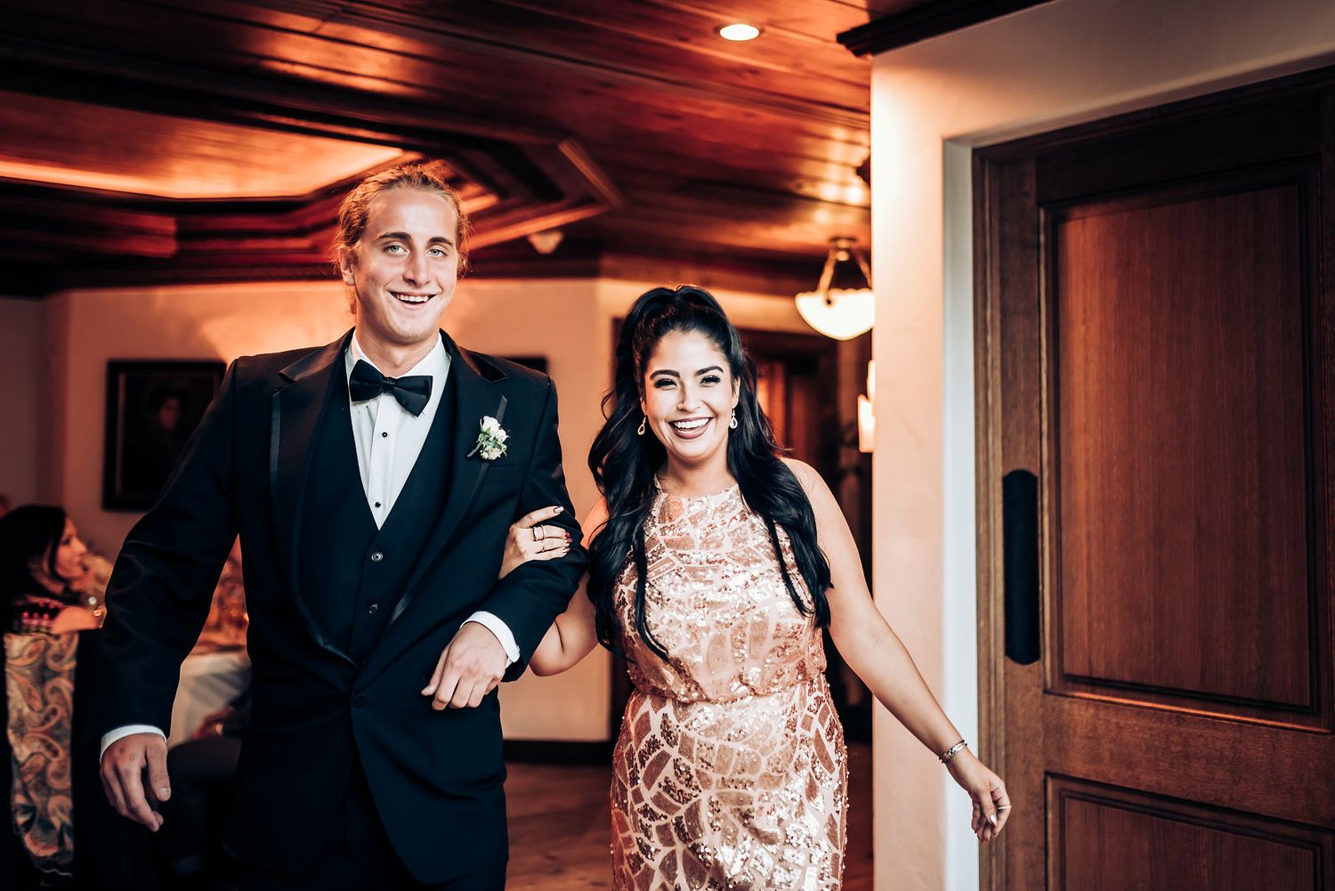Formal couple making a grand entrance in elegant evening attire.