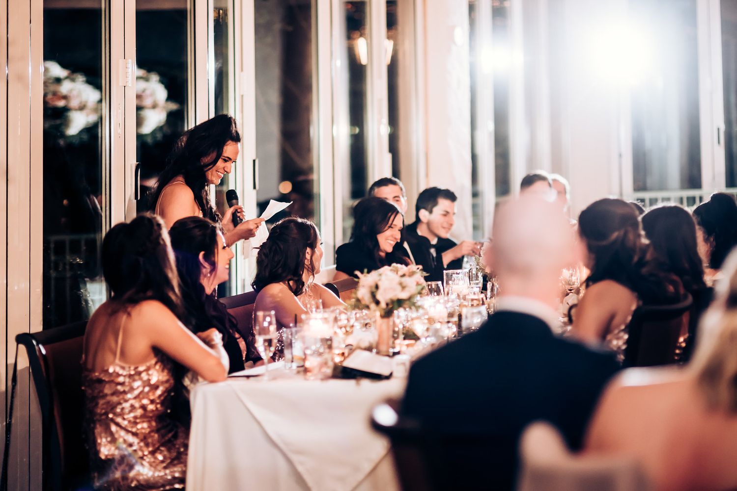Formal wedding reception dinner with guests seated at elegantly decorated tables with candlelight.