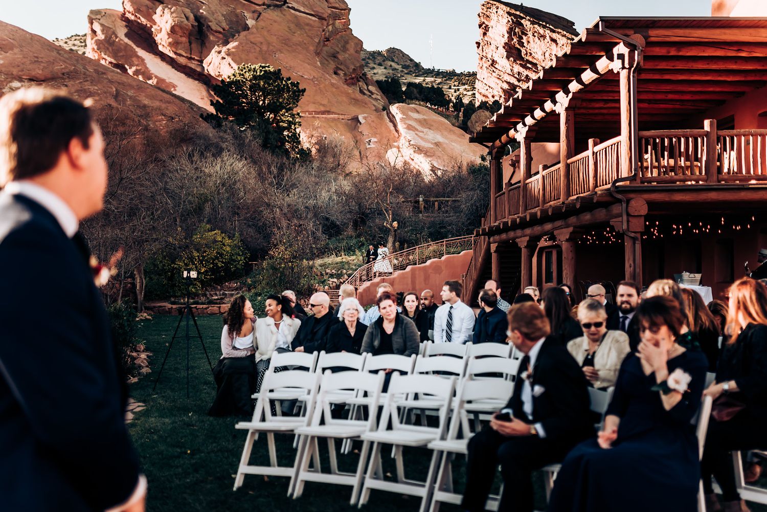 Scenic outdoor wedding venue with red rock formations and rustic wooden building.