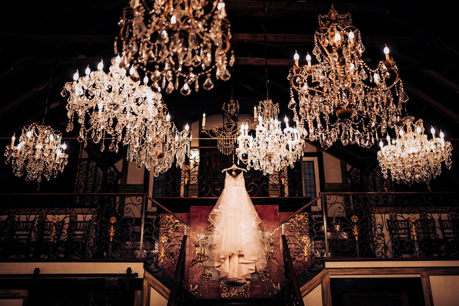 A dramatic wedding scene with multiple crystal chandeliers illuminating a grand ballroom.
