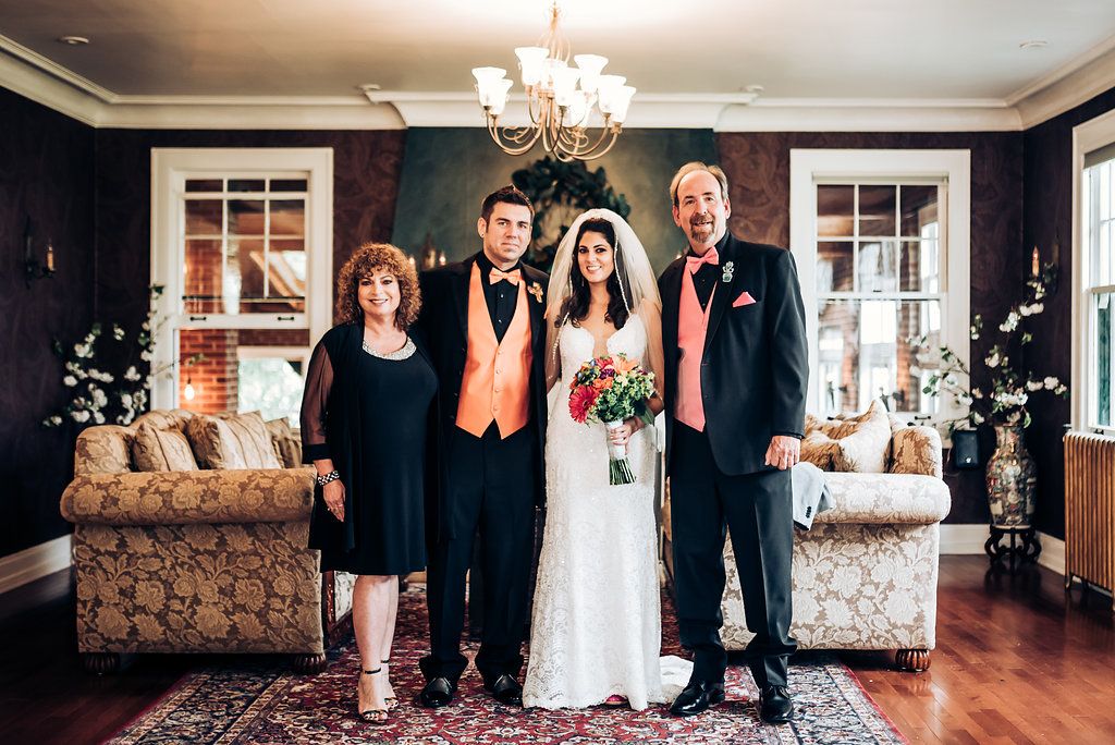 Wedding portrait in elegant room with chandelier and cream-colored sofas.