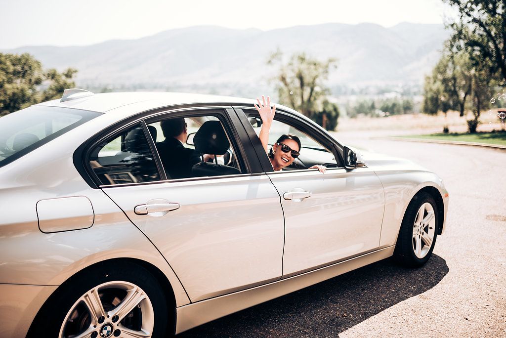 Silver BMW sedan parked on a scenic mountain road.