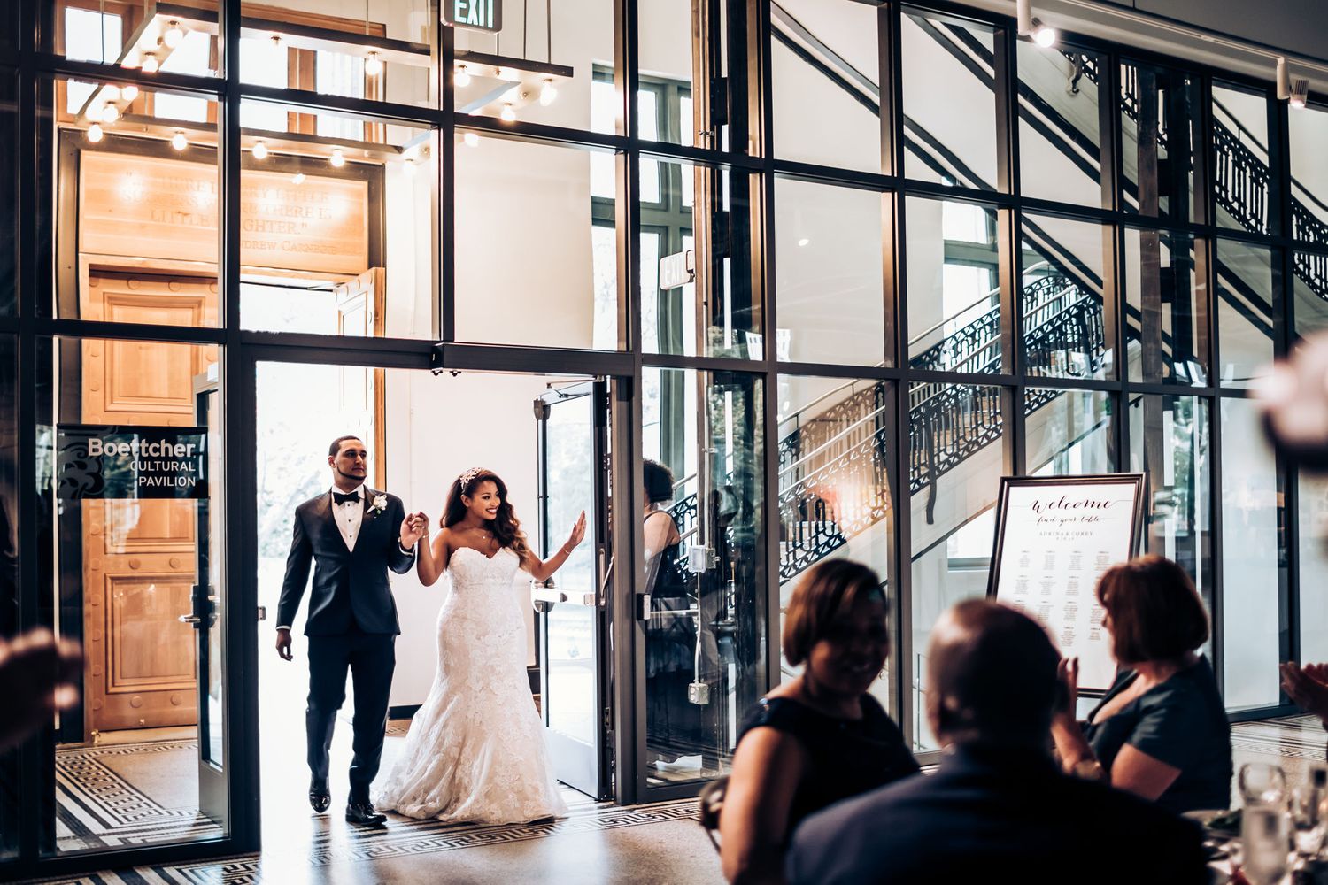 Grand entrance to wedding celebration through modern glass doorway.