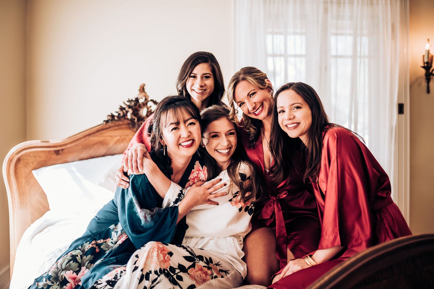 A celebratory moment captured on an ornate bed during wedding preparation festivities.