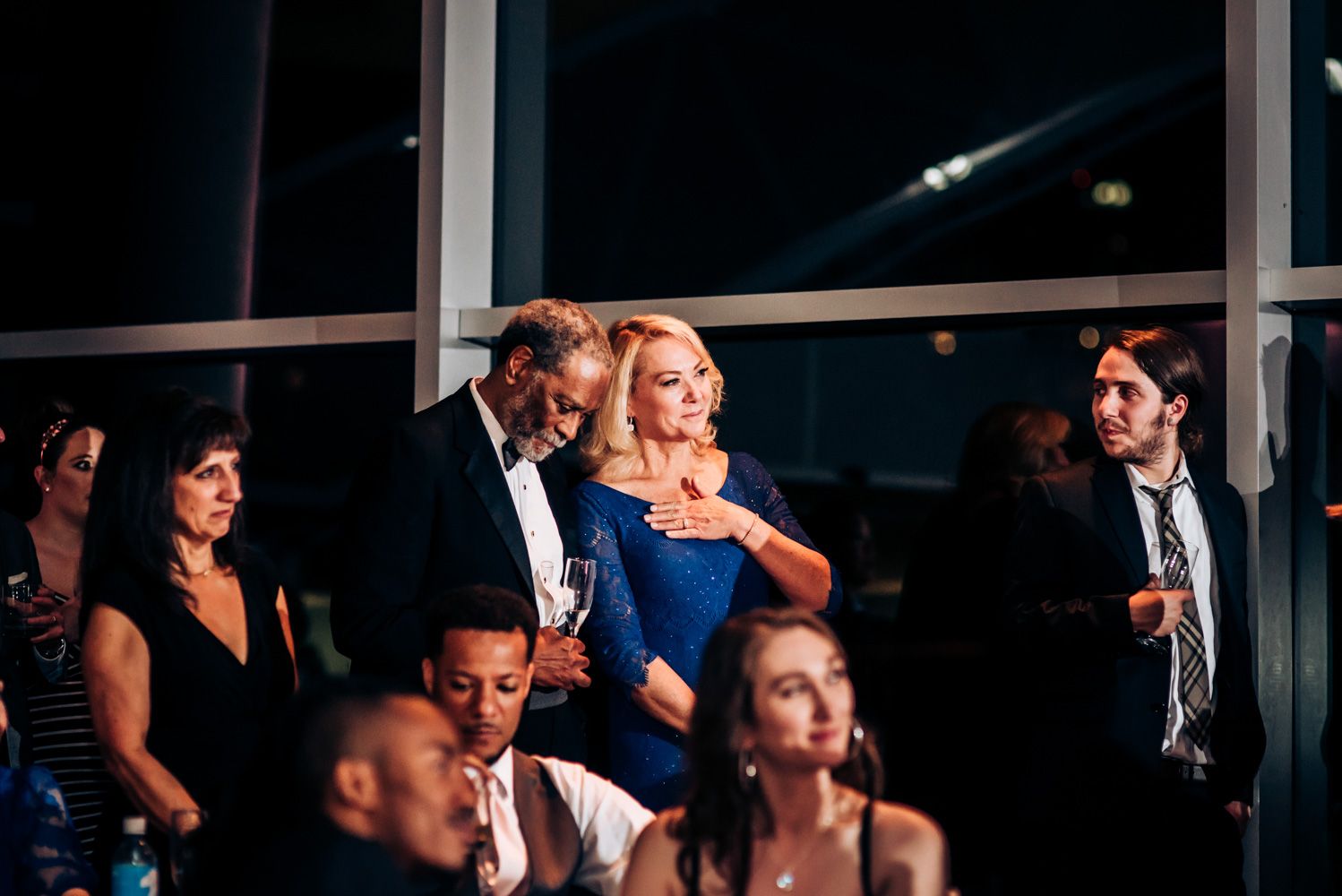 Elegant evening wedding reception with guests mingling in formal attire.