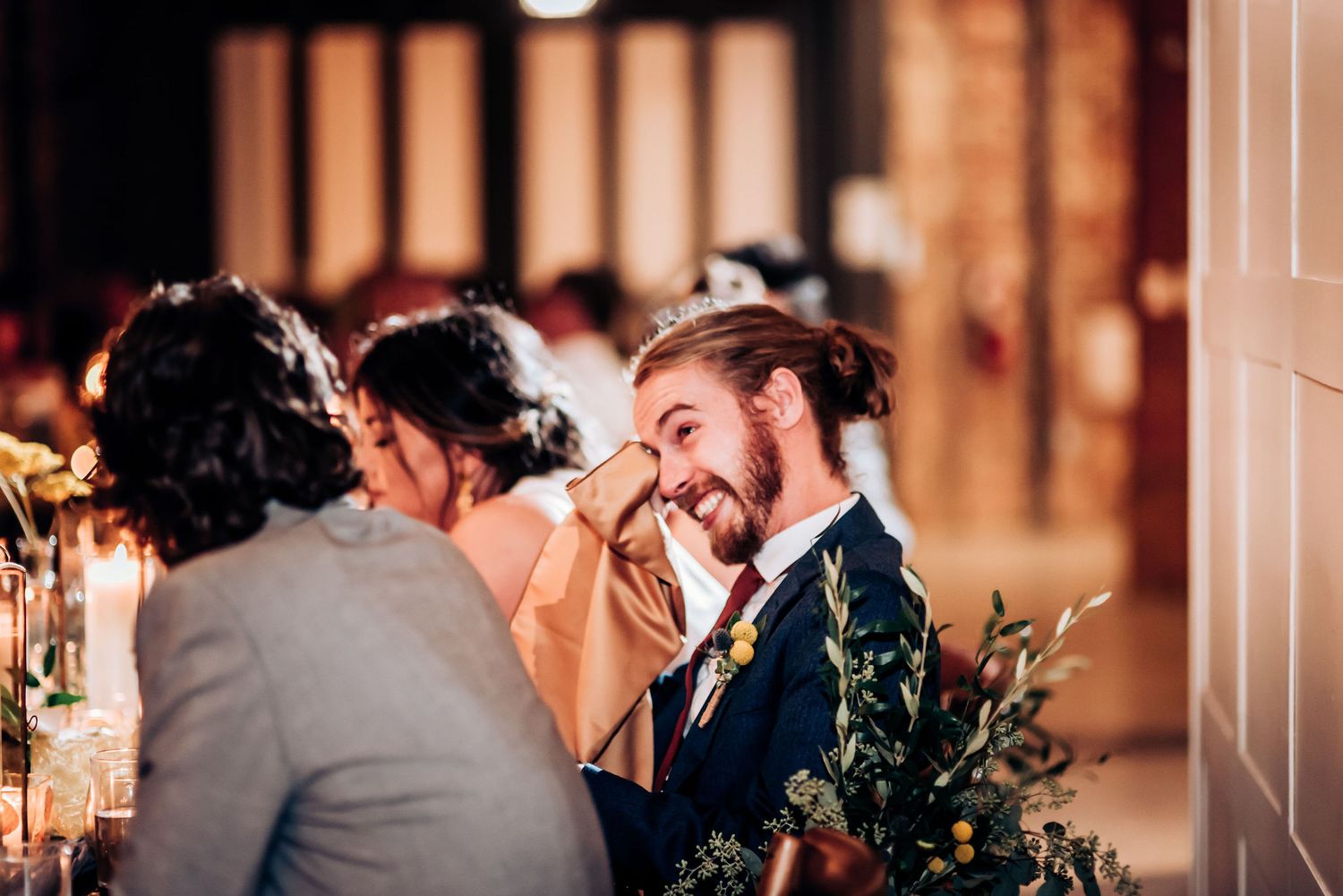 Lively conversation and laughter during an intimate wedding reception dinner.