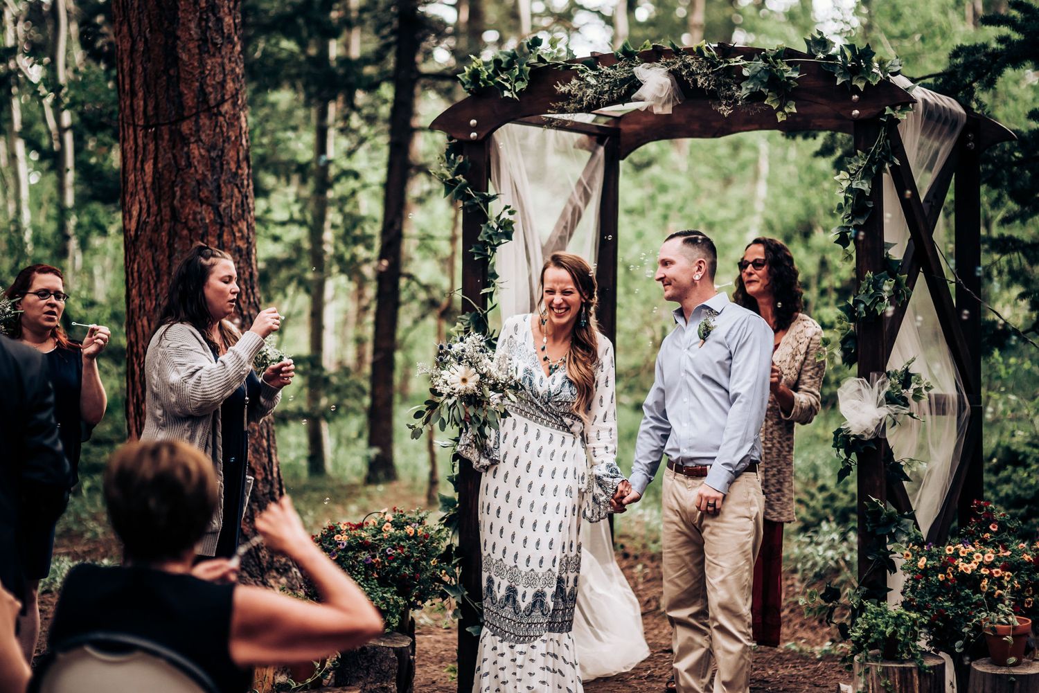 A celebratory moment during an outdoor wedding ceremony with guests watching from their seats.