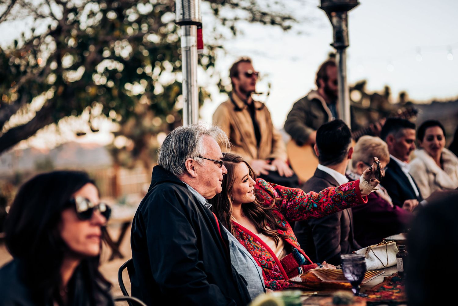 Guests enjoying an outdoor gathering at sunset with desert views.