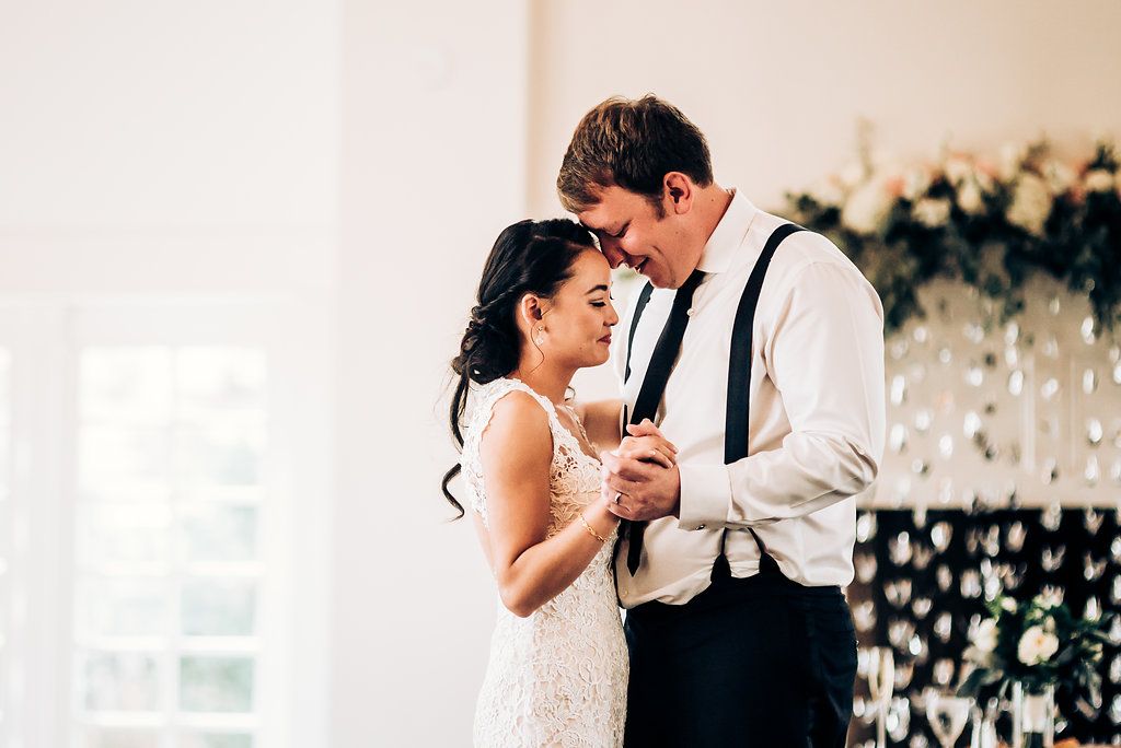 A tender moment shared during first dance at an elegant indoor wedding reception.