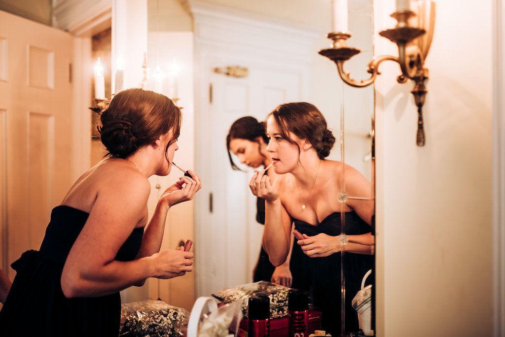 Group of friends sharing laughter and conversation by an elegant wall sconce.