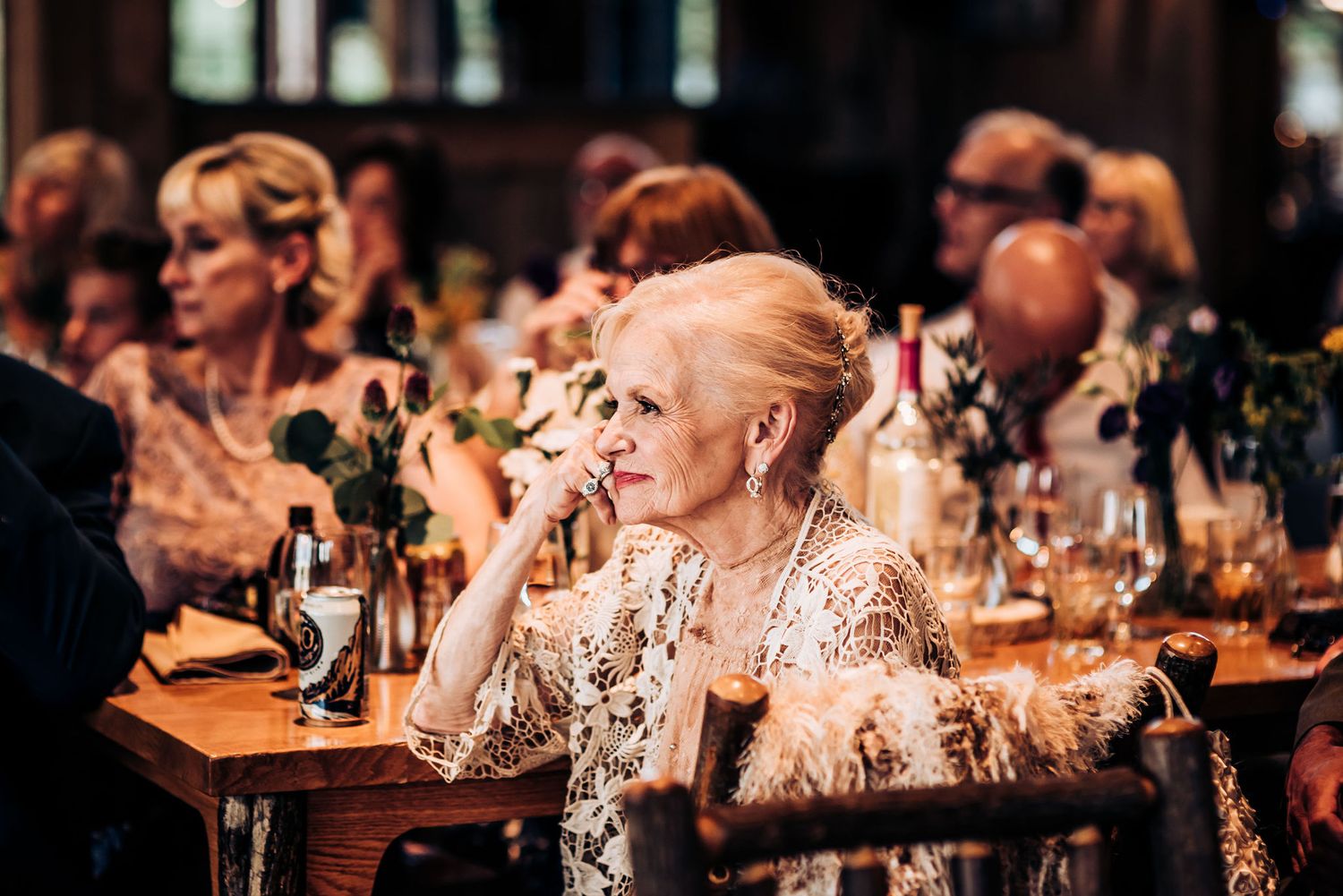 Guests enjoy an elegant dinner reception with warm lighting and table decorations at a formal event.