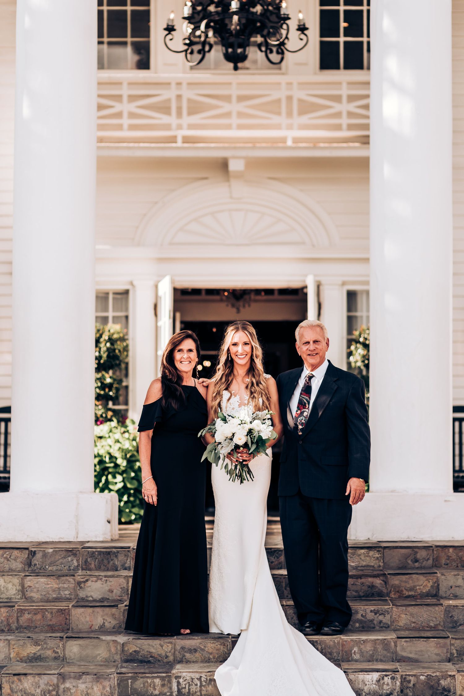 Classic formal portrait on mansion steps with elegant columns and archway.