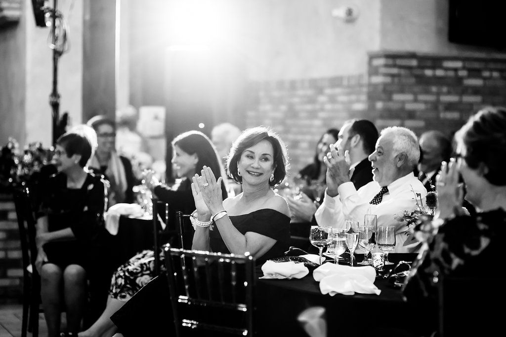 Black and white photo of wedding reception guests enjoying celebration.